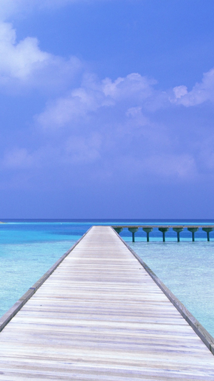 Brown Wooden Dock on Blue Sea Under Blue Sky During Daytime. Wallpaper in 720x1280 Resolution