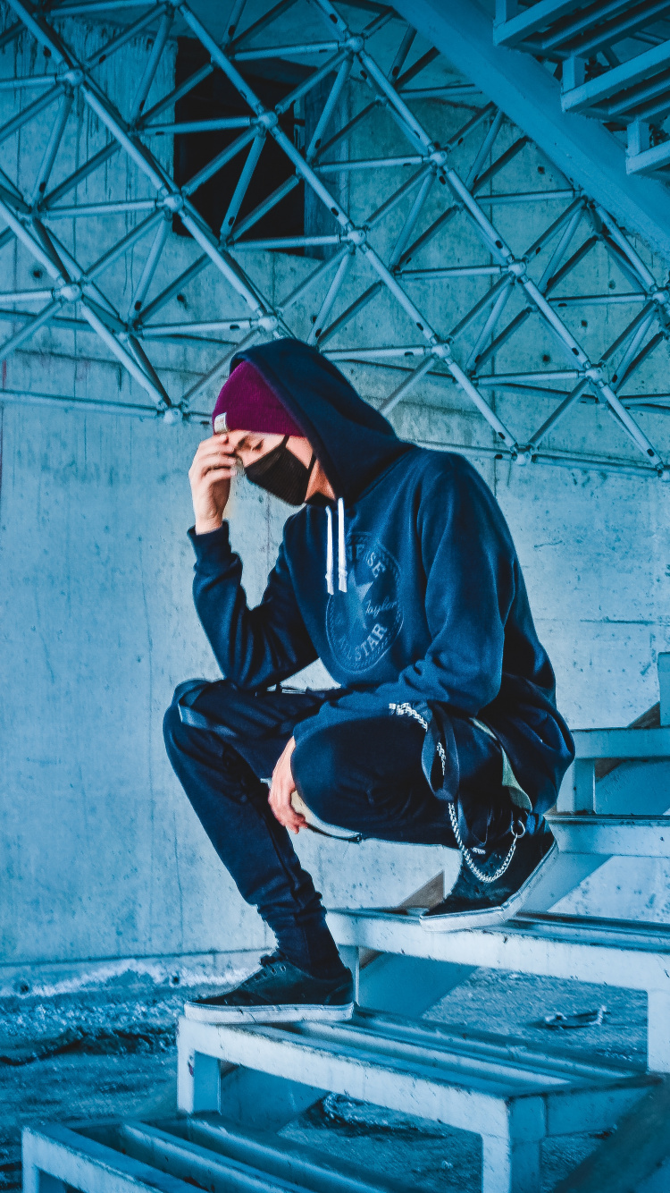 Man in Black Hoodie and Black Pants Sitting on Concrete Stairs. Wallpaper in 750x1334 Resolution