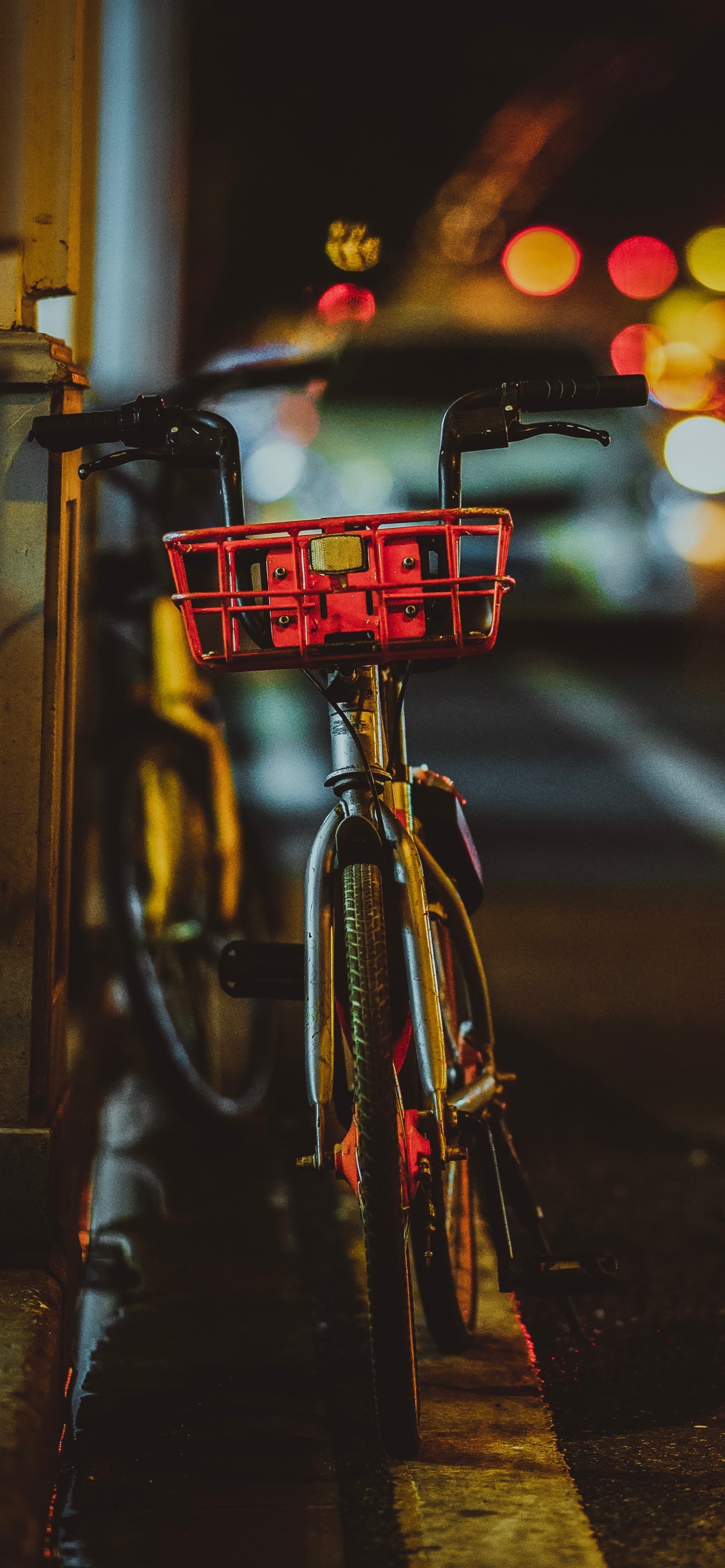 Vélo de Ville Rouge et Noir Garé Sur le Trottoir Pendant la Nuit. Wallpaper in 1242x2688 Resolution