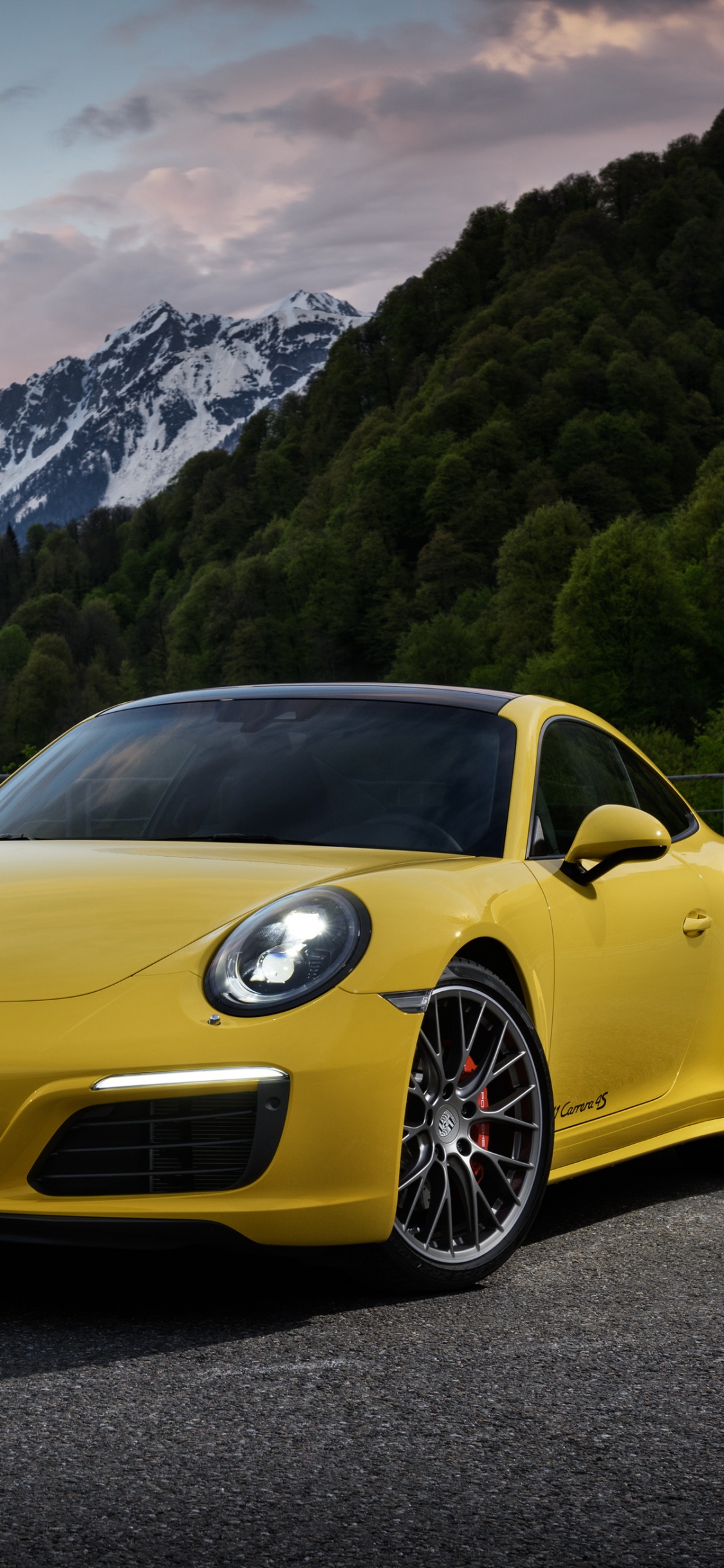 Porsche 911 Amarillo en la Carretera Cerca de la Montaña Durante el Día. Wallpaper in 1125x2436 Resolution