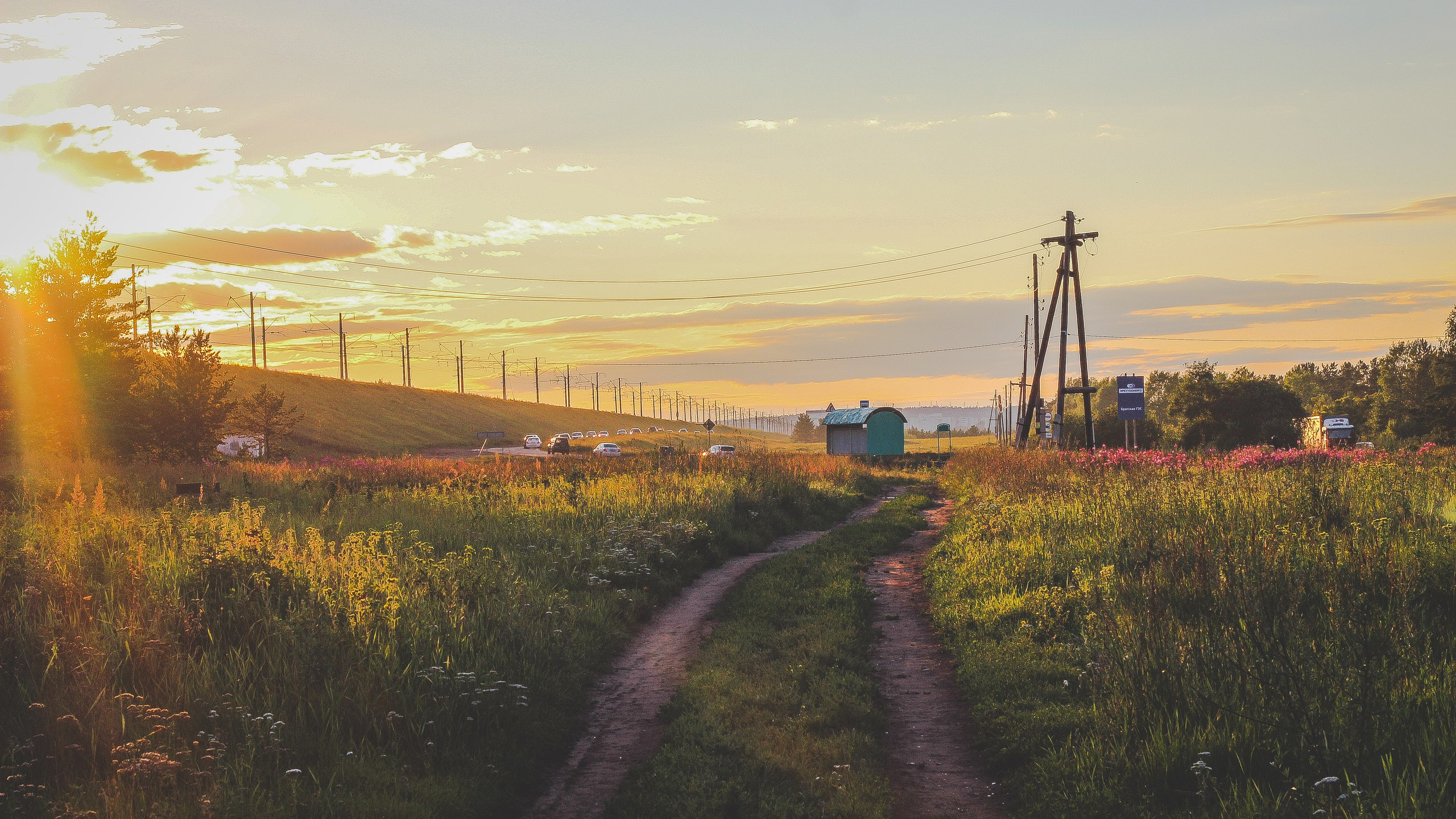 Green Grass Field Near Body of Water During Sunset. Wallpaper in 2560x1440 Resolution
