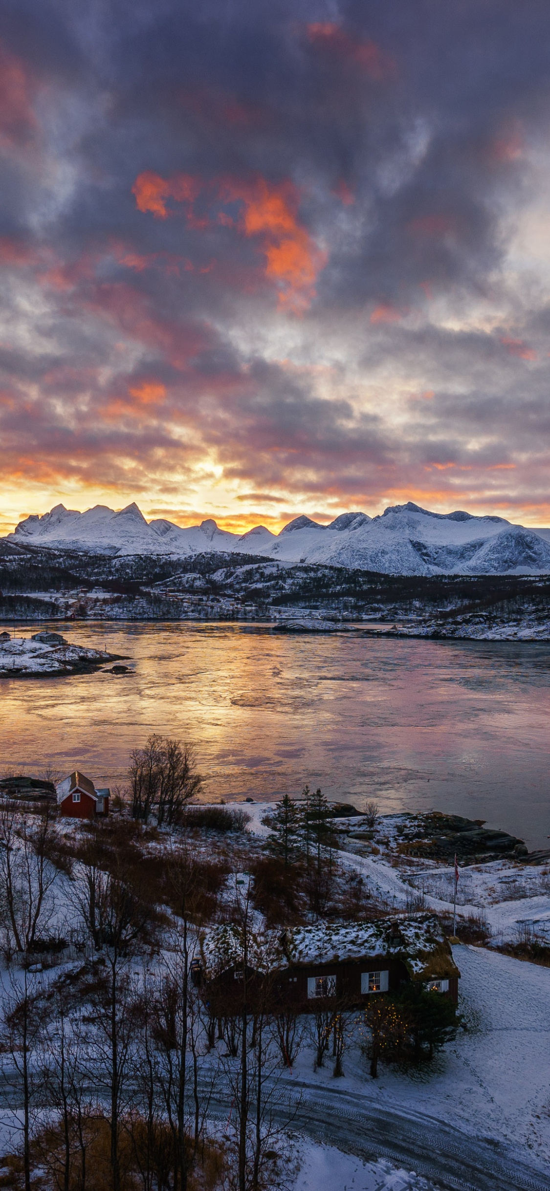 Champ Couvert de Neige Près D'un Plan D'eau Sous un Ciel Nuageux Pendant la Journée. Wallpaper in 1125x2436 Resolution