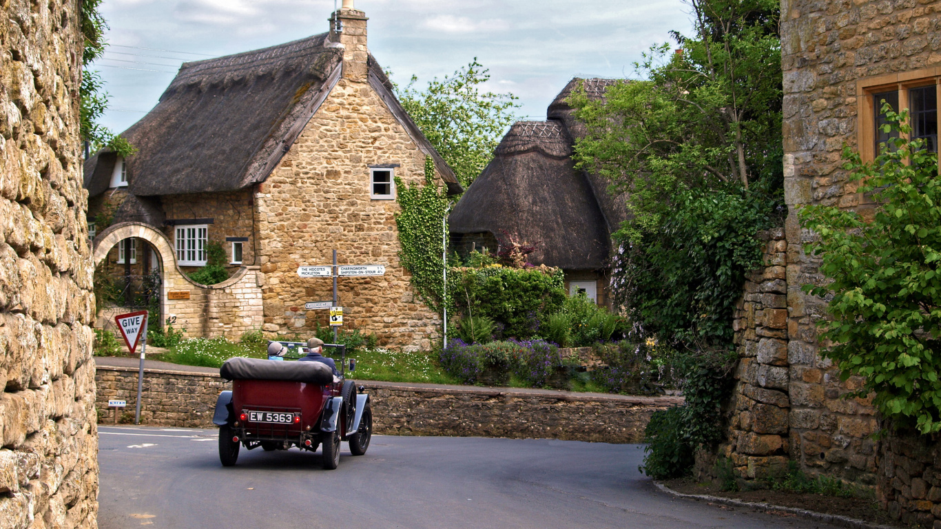 Red Car Parked Beside Brown House During Daytime. Wallpaper in 1366x768 Resolution