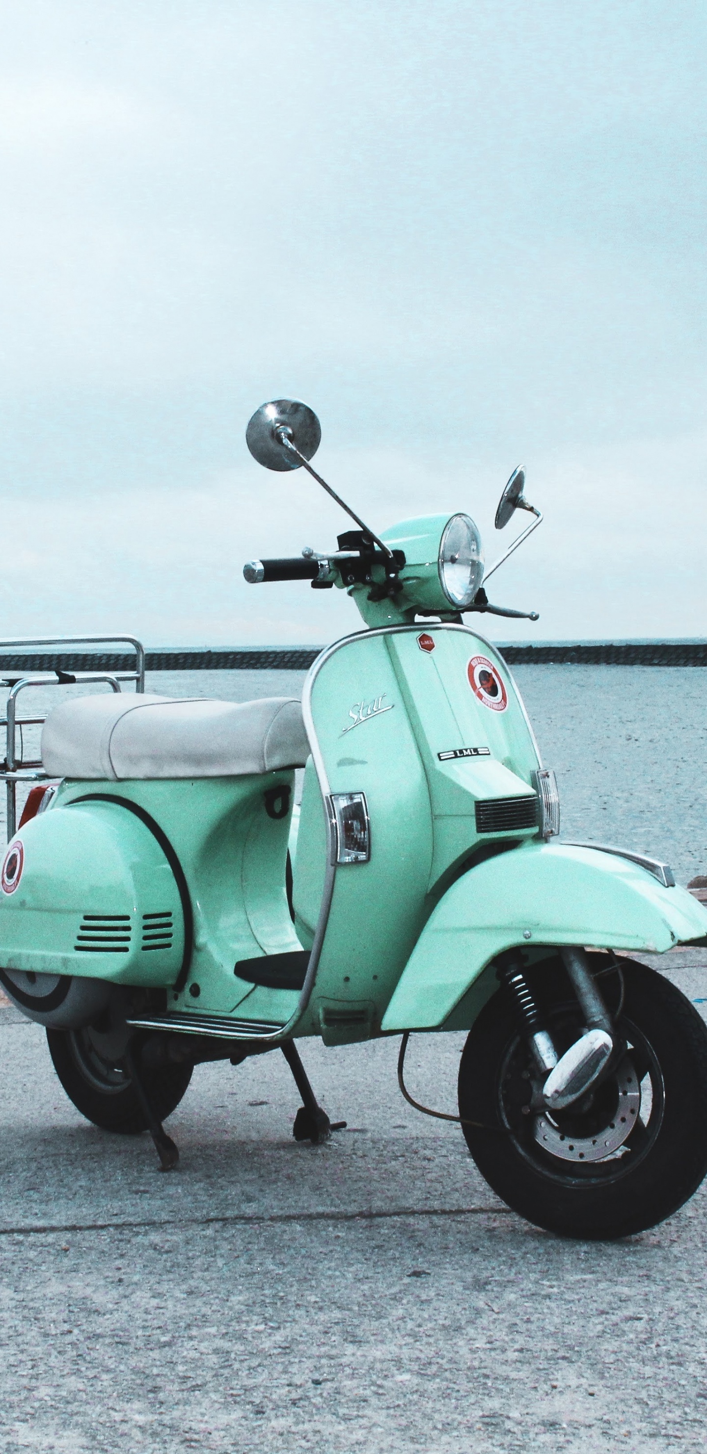 Moto Verde Estacionada Sobre Pavimento de Hormigón Gris Cerca Del Cuerpo de Agua Durante el Día. Wallpaper in 1440x2960 Resolution