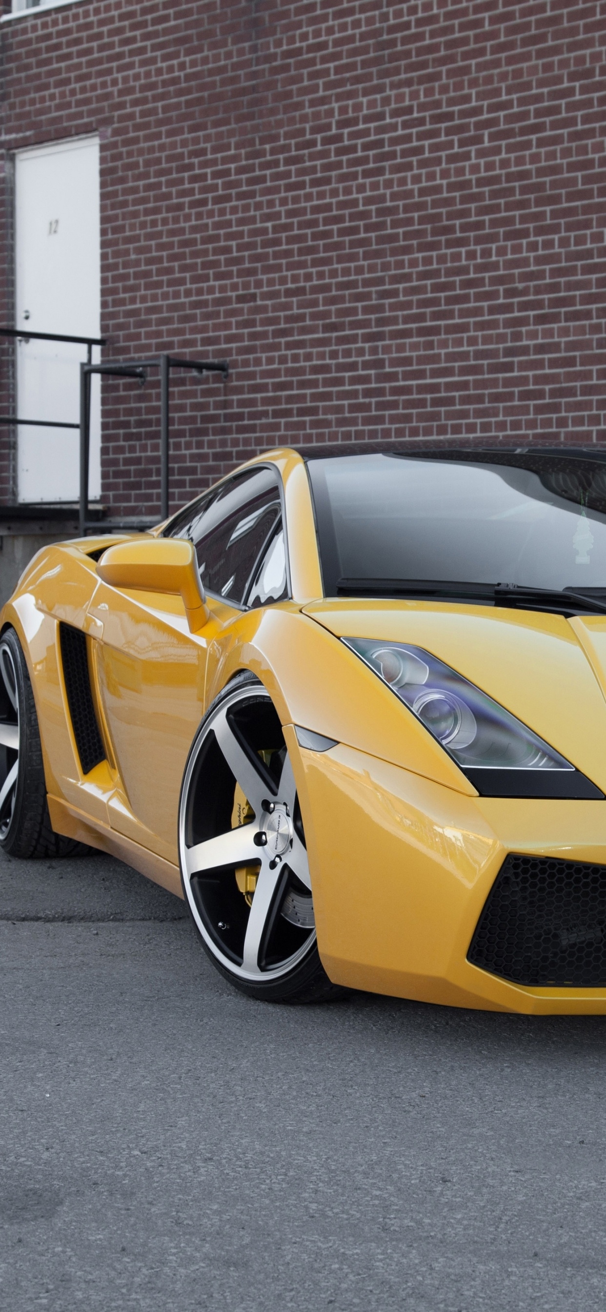 Ferrari 458 Italia Amarillo Estacionado Cerca Del Edificio de Ladrillo Marrón. Wallpaper in 1242x2688 Resolution