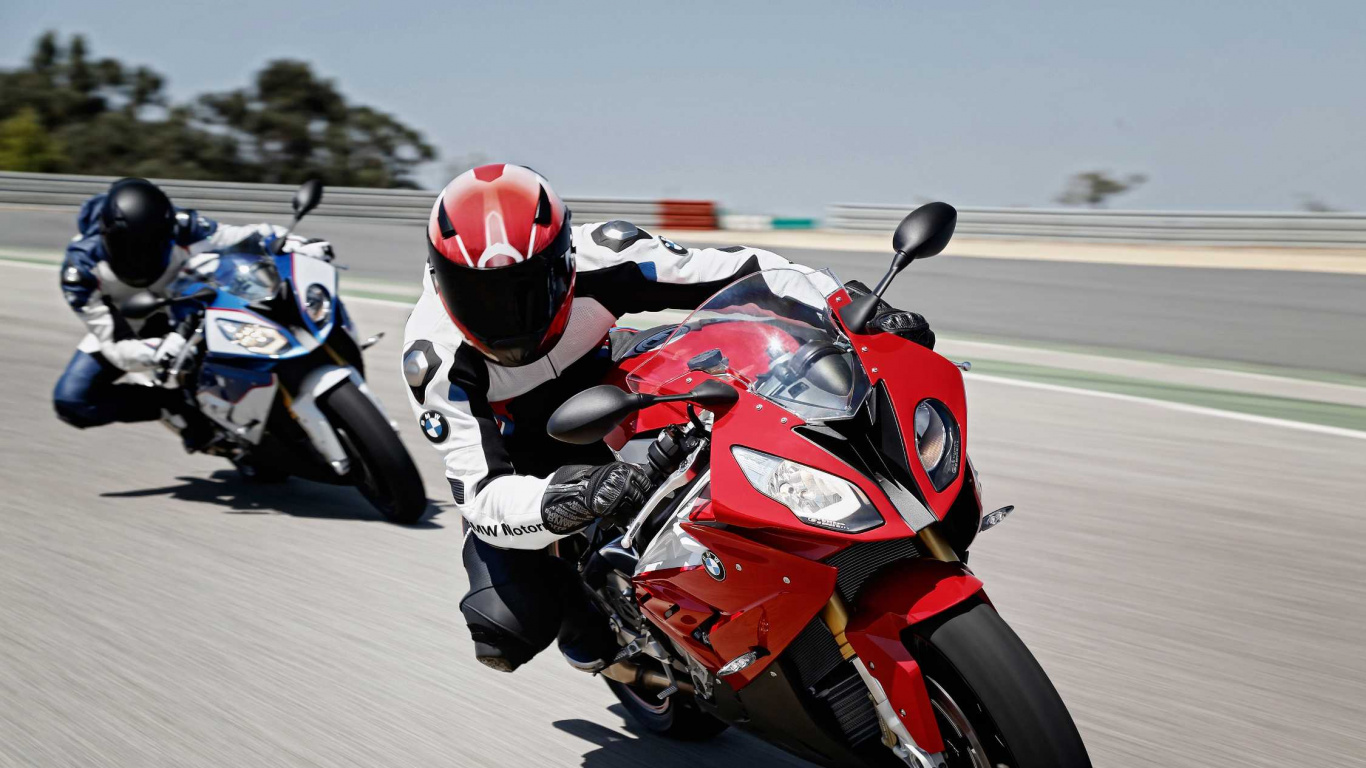 Mann im Roten Und Schwarzen Motorradanzug, Der Auf Einem Roten Und Weißen Sportmotorrad Fährt. Wallpaper in 1366x768 Resolution