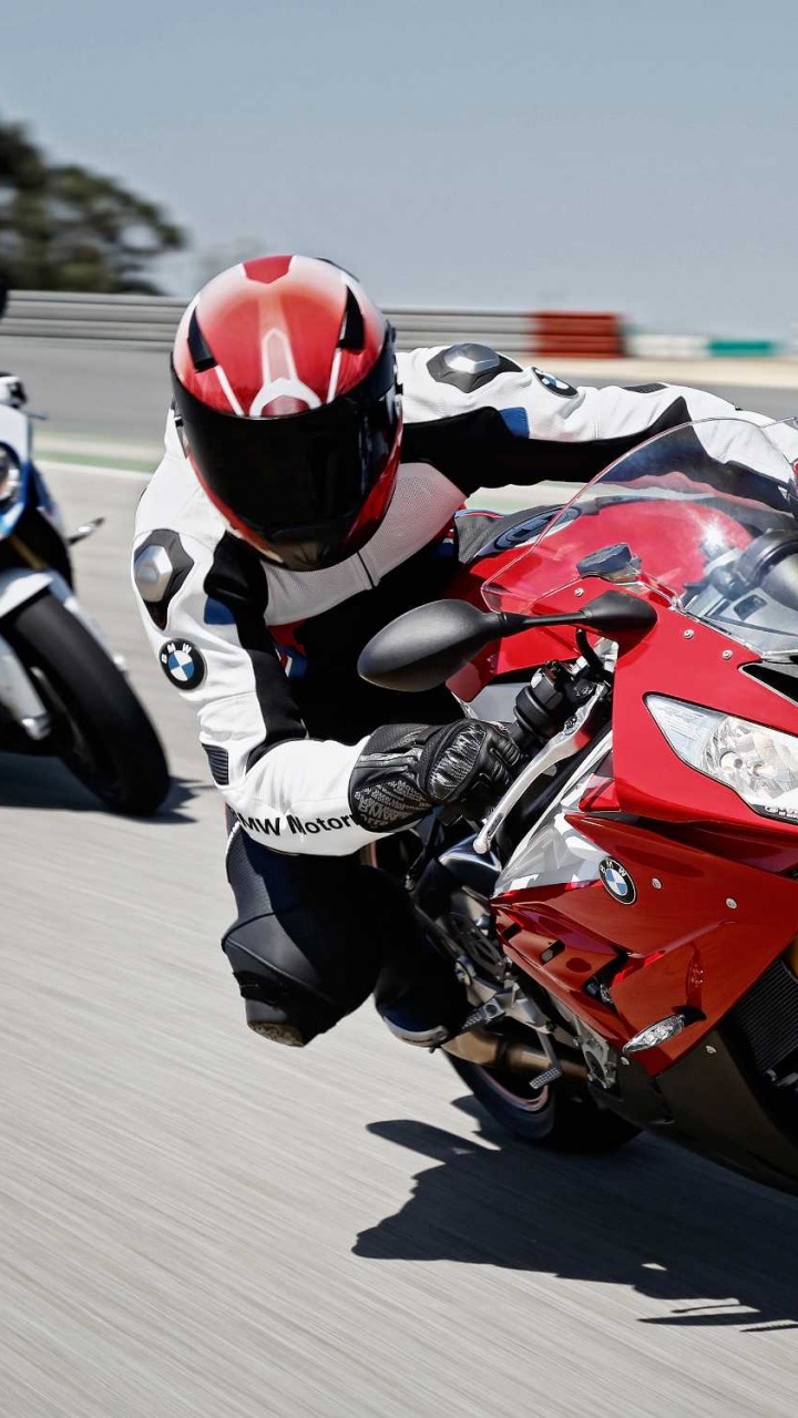 Mann im Roten Und Schwarzen Motorradanzug, Der Auf Einem Roten Und Weißen Sportmotorrad Fährt. Wallpaper in 720x1280 Resolution