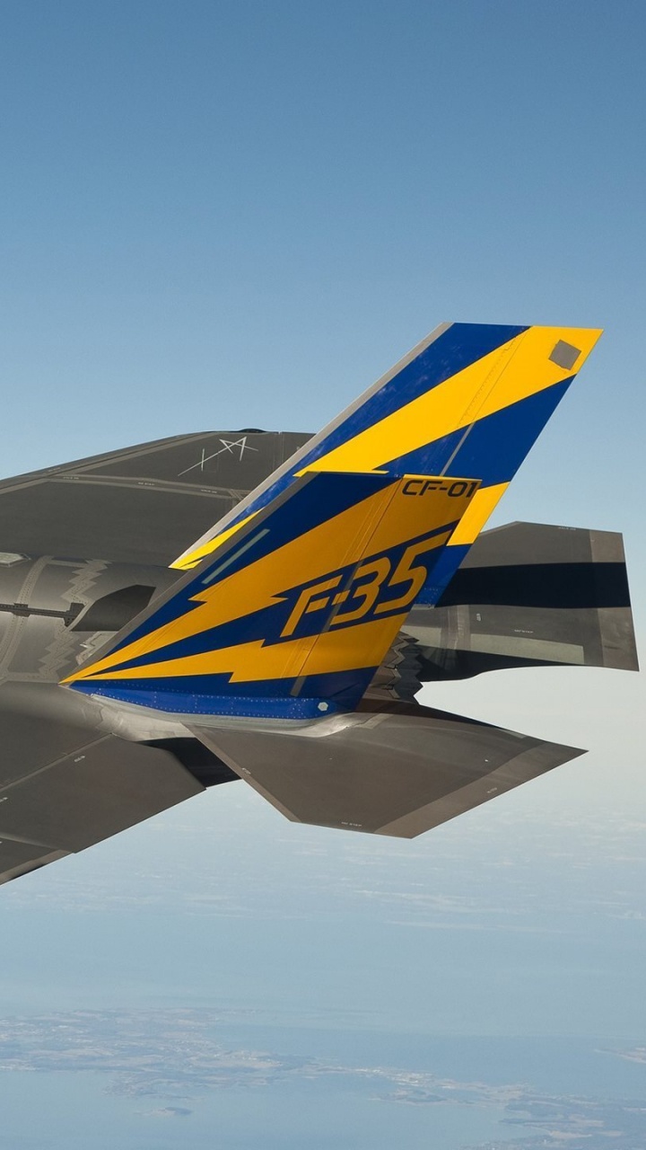 Avion à Réaction Noir et Jaune Dans Les Airs Pendant la Journée. Wallpaper in 720x1280 Resolution
