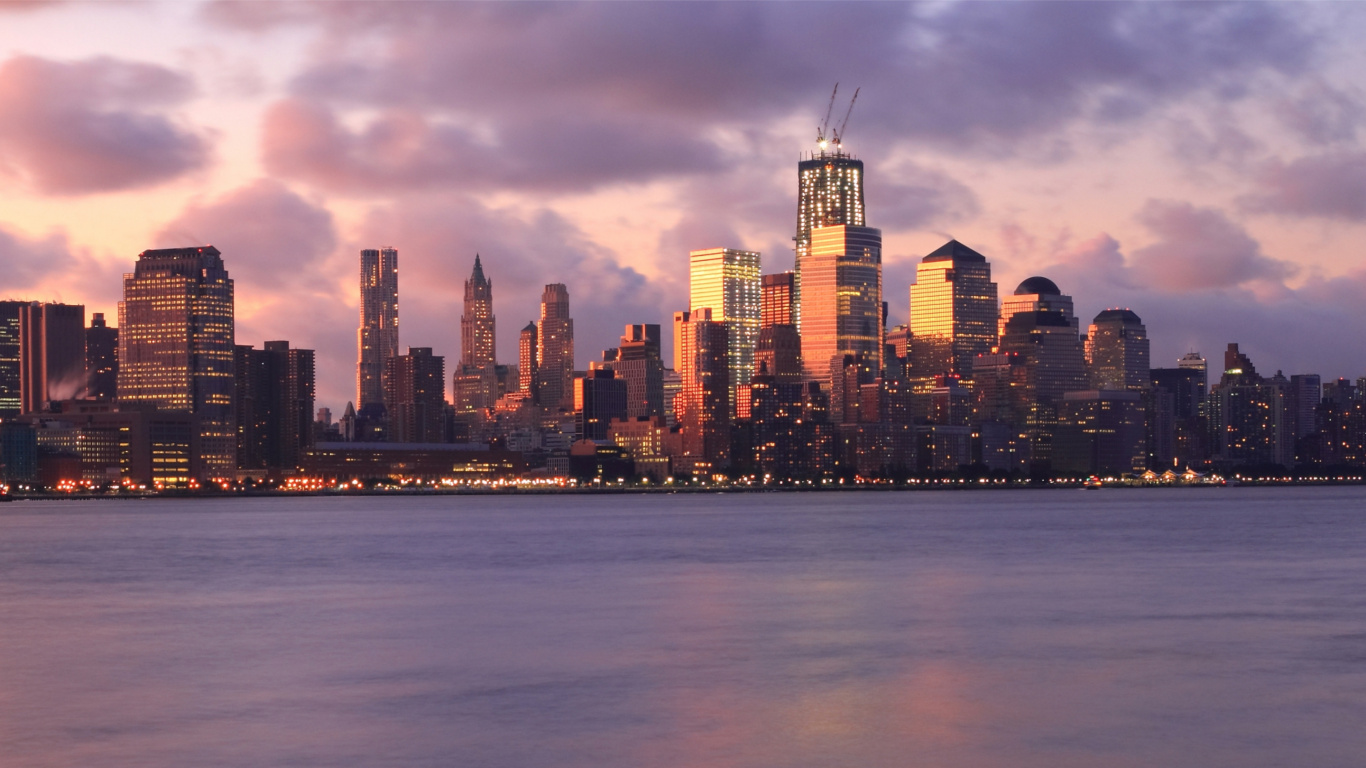 Skyline Der Stadt Über Gewässer Während Der Nacht. Wallpaper in 1366x768 Resolution