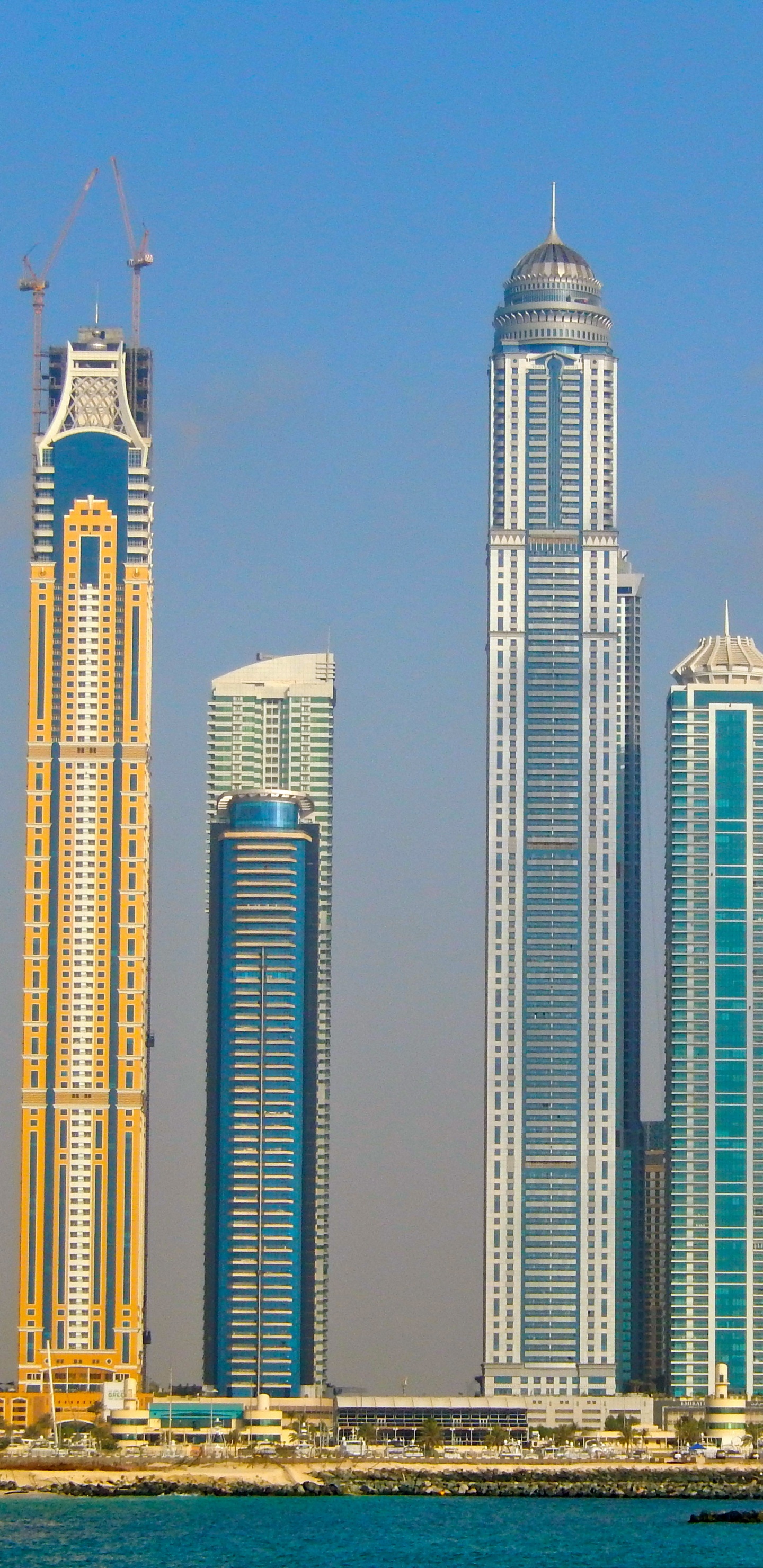 Weißes Hochhaus in Der Nähe Eines Gewässers Tagsüber. Wallpaper in 1440x2960 Resolution