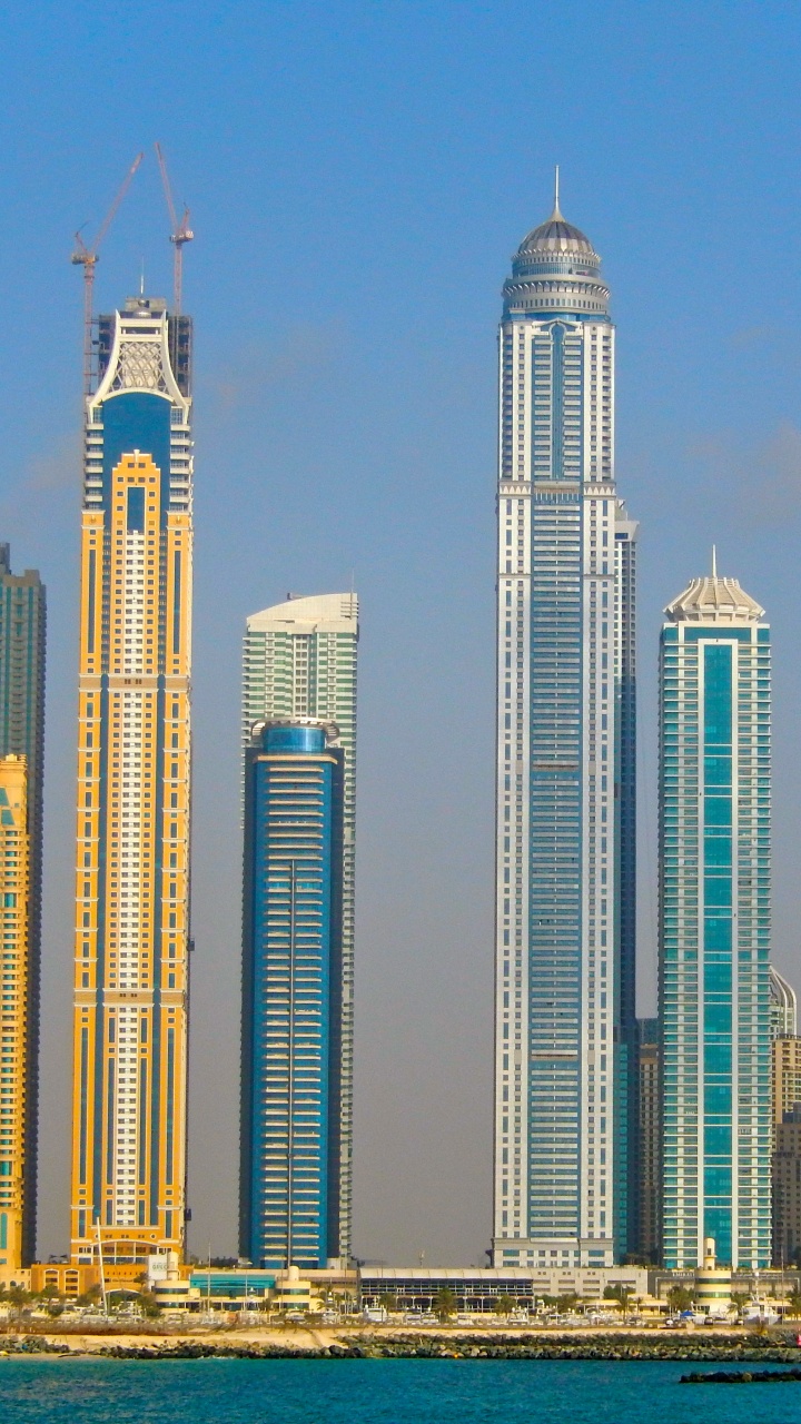 Weißes Hochhaus in Der Nähe Eines Gewässers Tagsüber. Wallpaper in 720x1280 Resolution