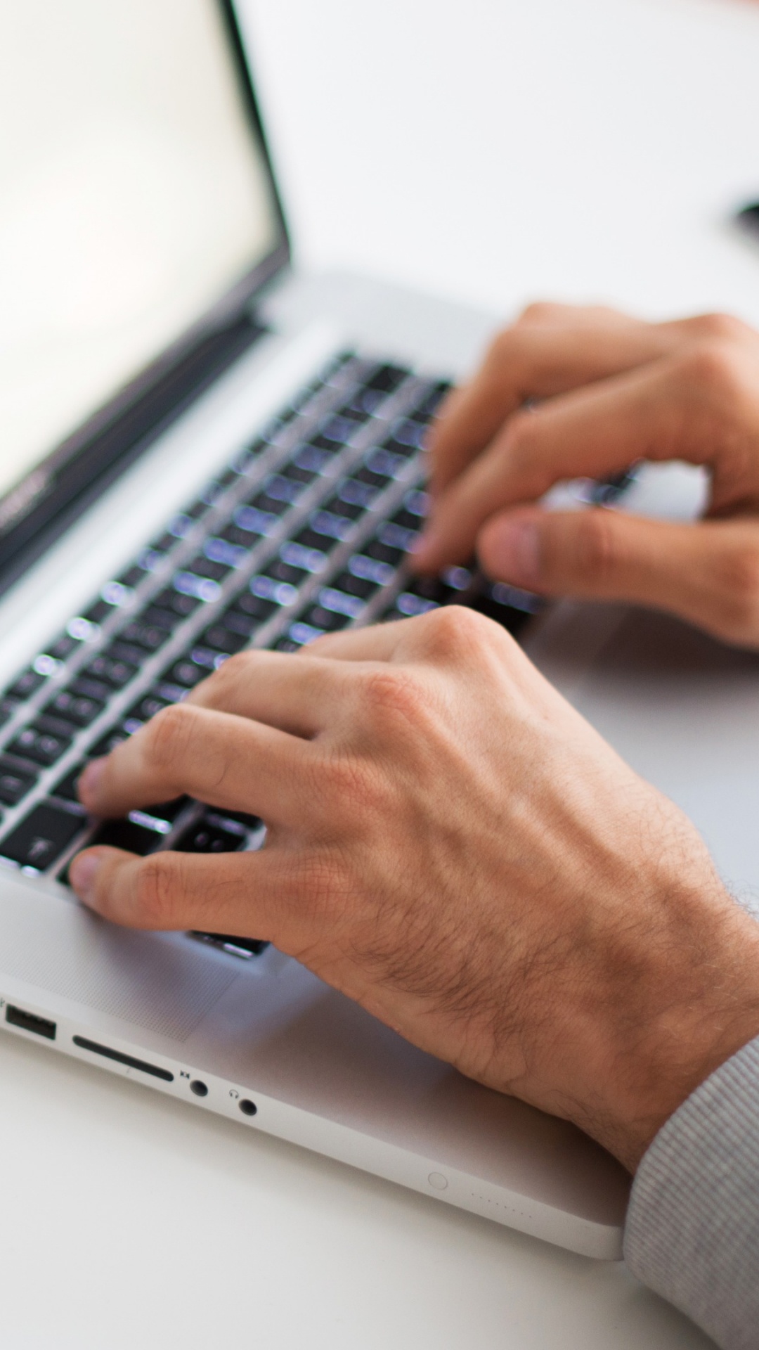 Person Using Macbook Pro on White Table. Wallpaper in 1080x1920 Resolution