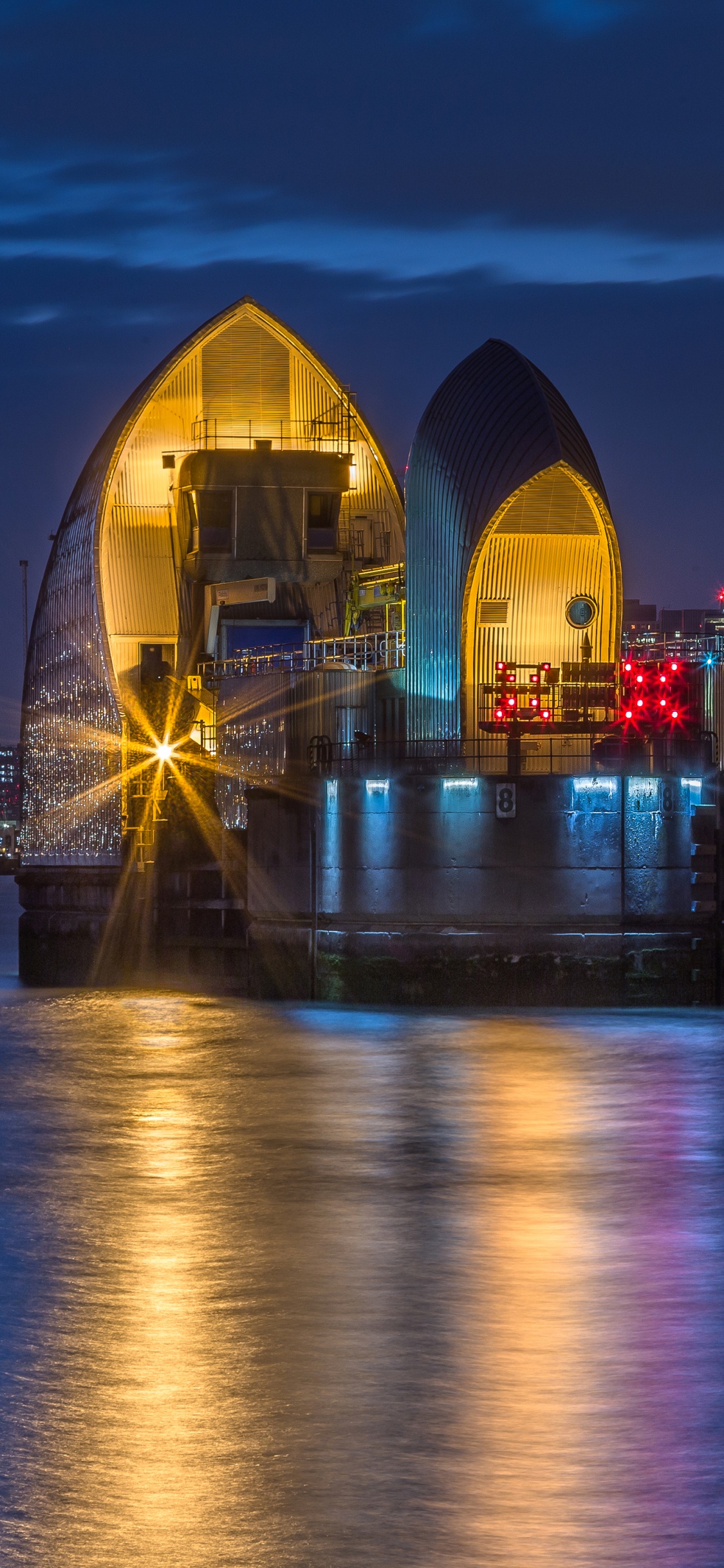 Weißes Und Schwarzes Gebäude in Der Nähe Eines Gewässers Während Der Nacht. Wallpaper in 1125x2436 Resolution