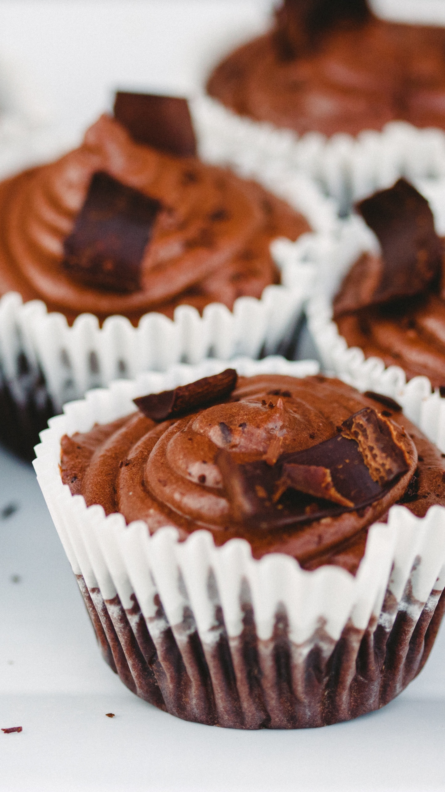 Cupcakes Mit Schokolade Und Sahne Auf Weißem Keramikteller. Wallpaper in 1440x2560 Resolution