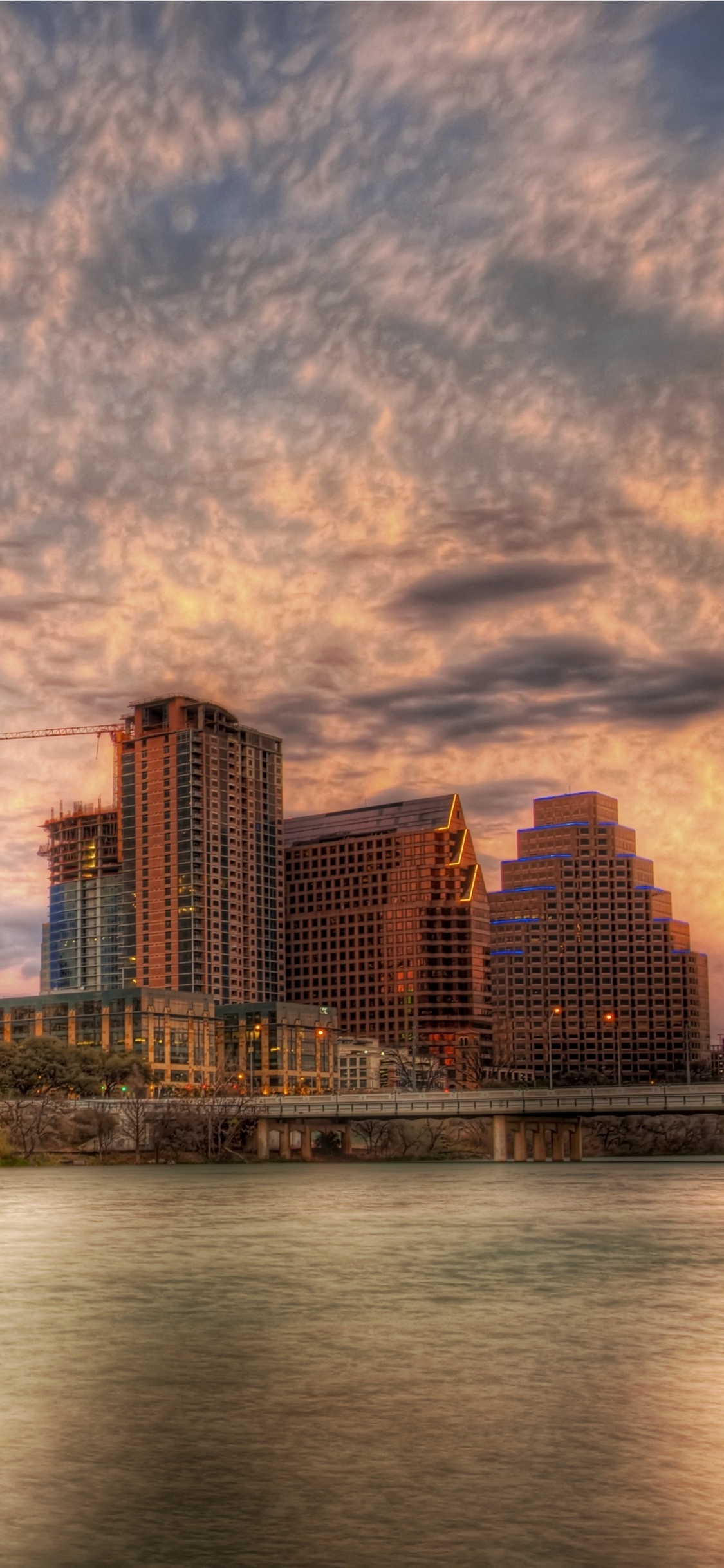 City Skyline Under Cloudy Sky During Daytime. Wallpaper in 1125x2436 Resolution