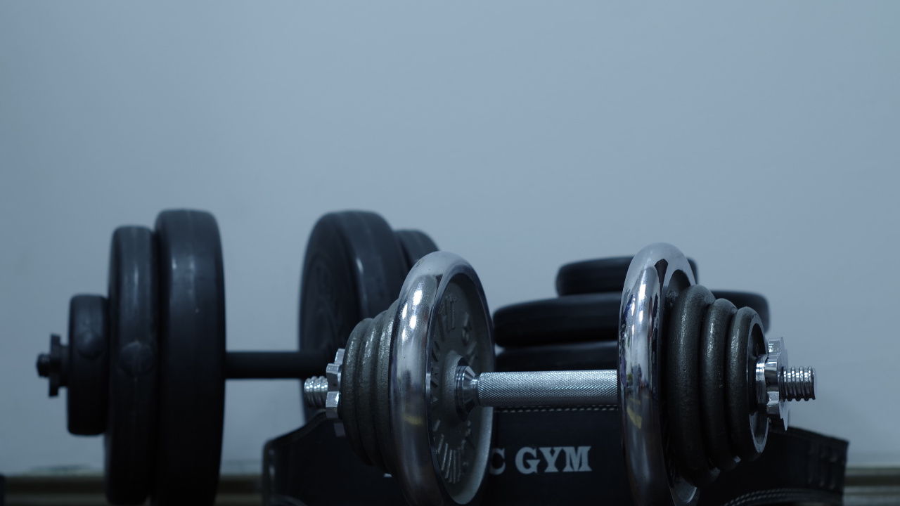 2 Black Dumbbells on Brown Wooden Table. Wallpaper in 1280x720 Resolution