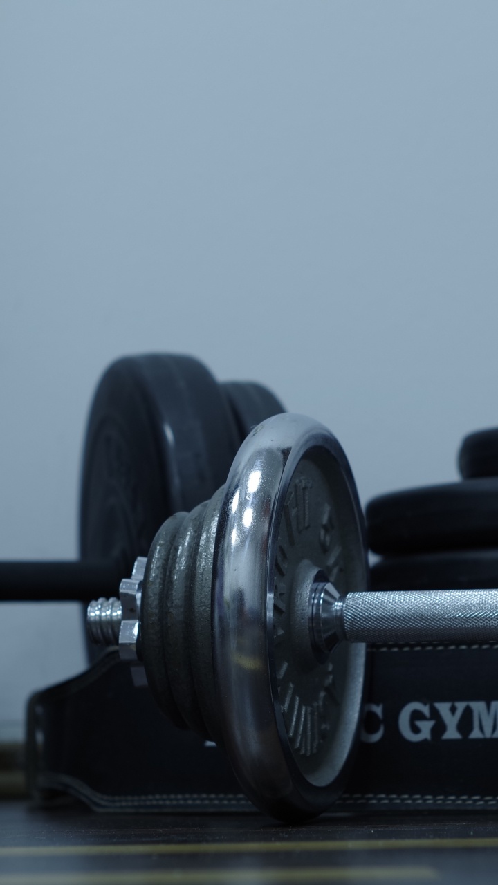 2 Black Dumbbells on Brown Wooden Table. Wallpaper in 720x1280 Resolution