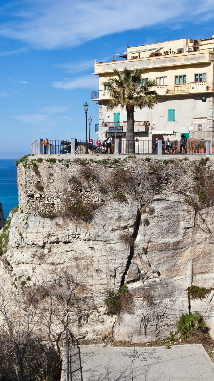 White Concrete Building on Top of Brown Rocky Mountain Under Blue Sky During Daytime. Wallpaper in 750x1334 Resolution