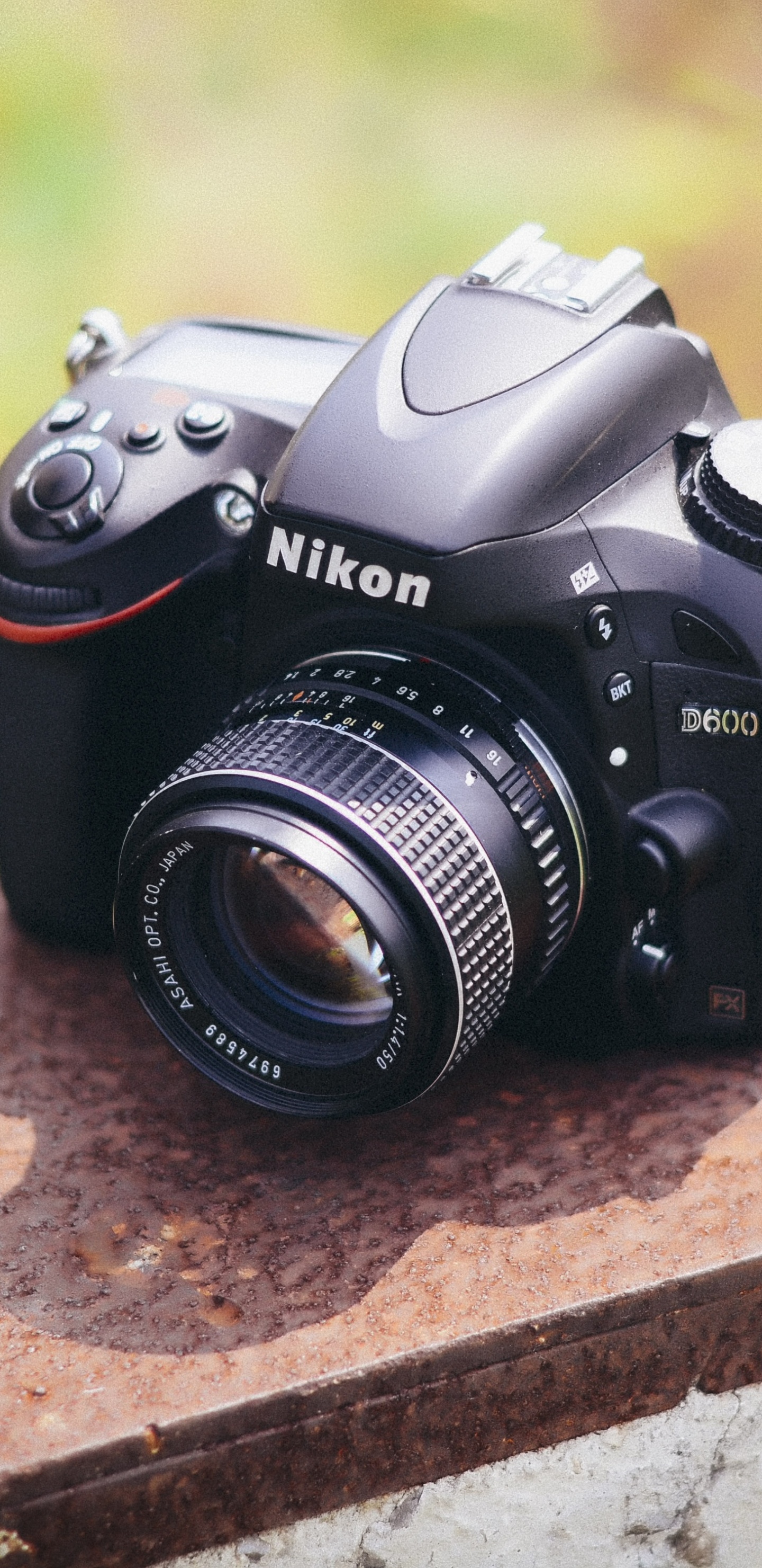 Schwarze Nikon Dslr Kamera Auf Brauner Betonoberfläche. Wallpaper in 1440x2960 Resolution