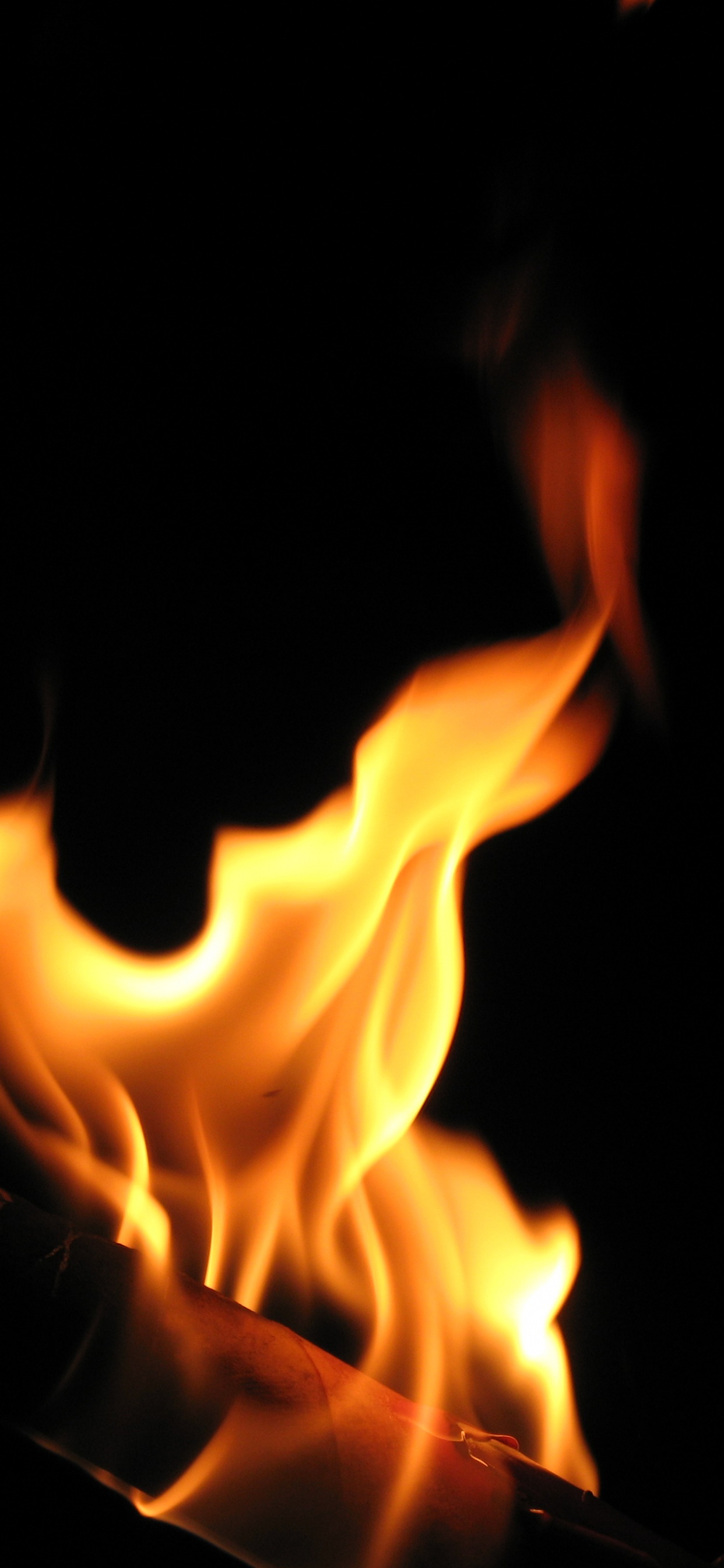 Orange Fire in Black Background. Wallpaper in 1242x2688 Resolution