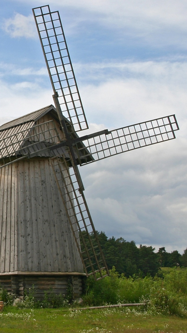 Braunes Holzhaus Auf Grüner Wiese Unter Weißen Wolken Tagsüber. Wallpaper in 720x1280 Resolution