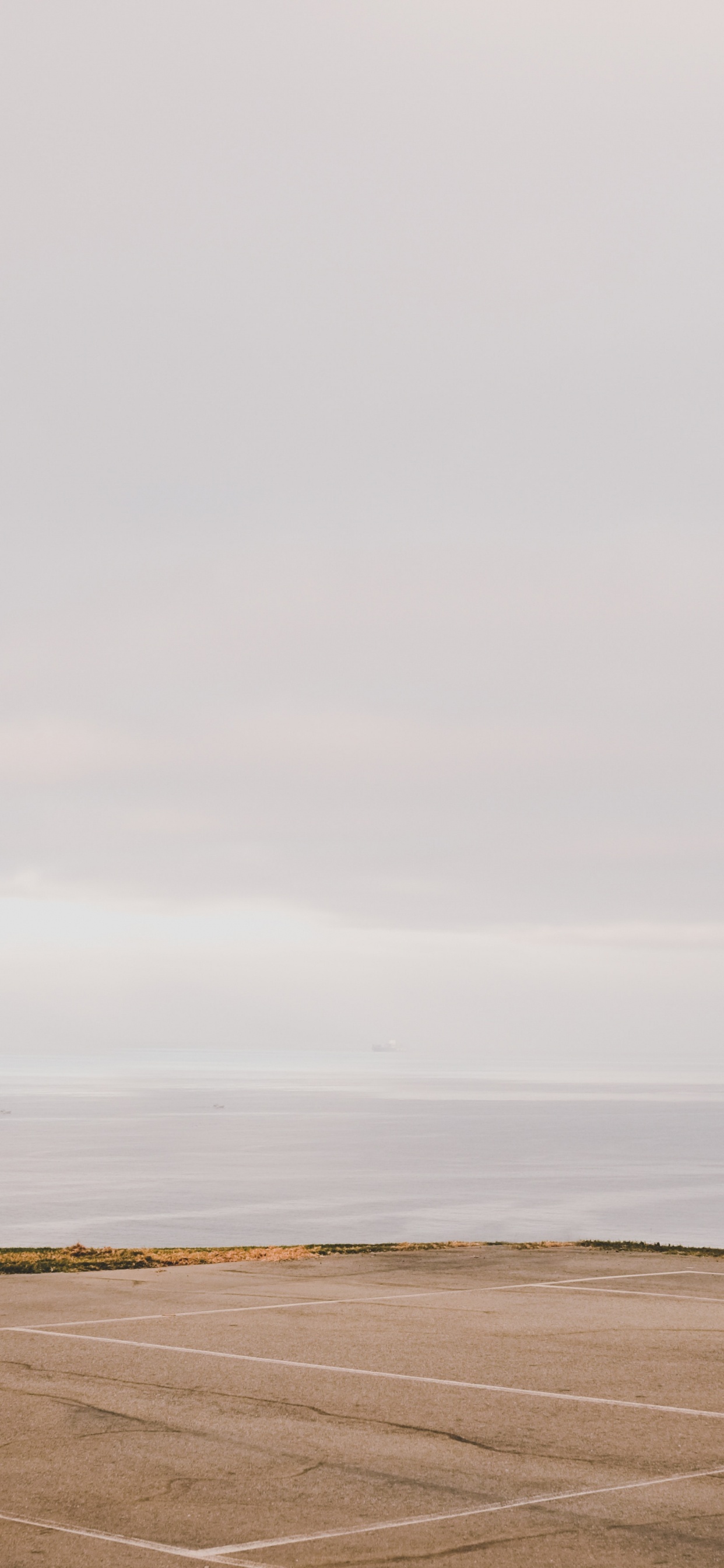 Basketball Hoop on Brown Sand Under White Sky During Daytime. Wallpaper in 1242x2688 Resolution