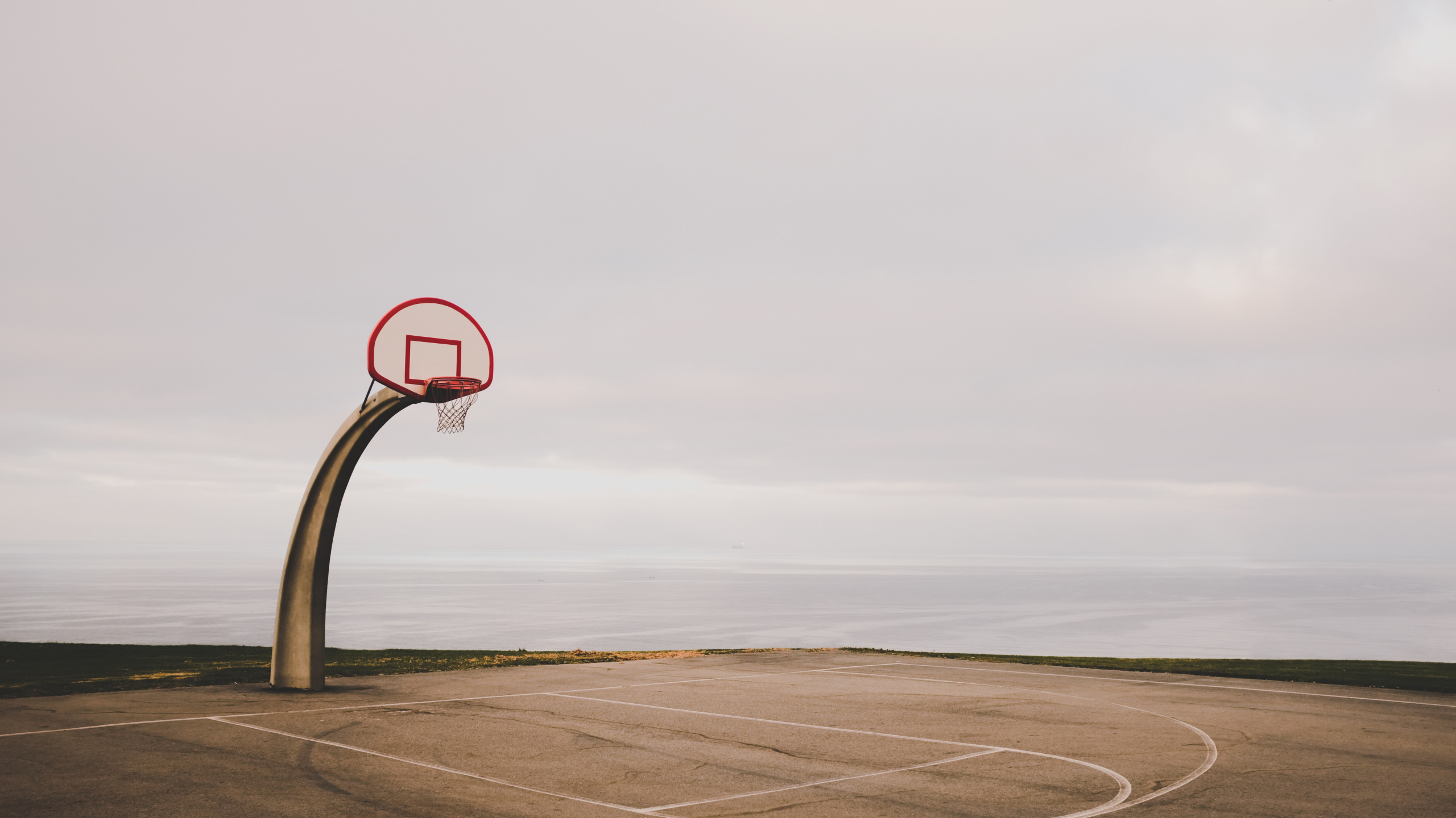 Basketball Hoop on Brown Sand Under White Sky During Daytime. Wallpaper in 2560x1440 Resolution
