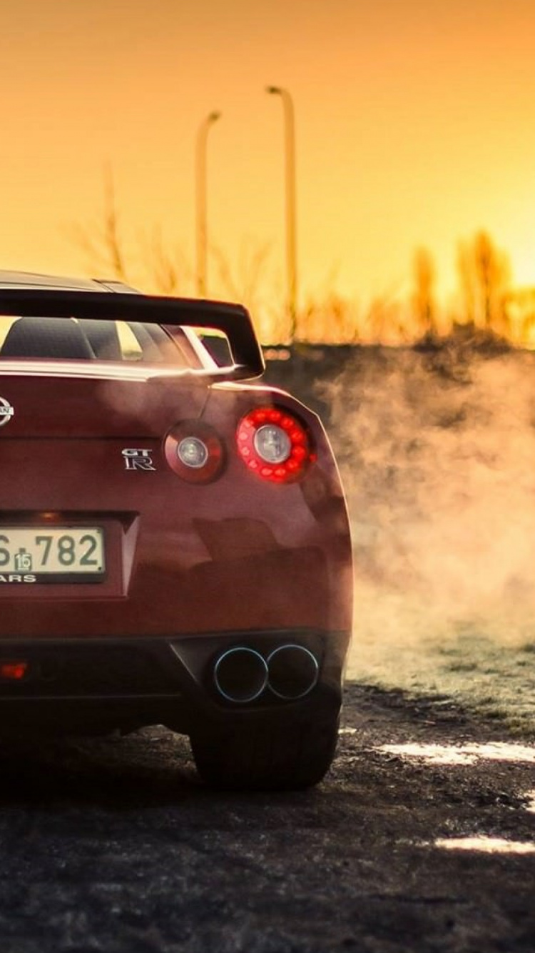Chevrolet Camaro Rojo en la Carretera Durante la Puesta de Sol. Wallpaper in 750x1334 Resolution