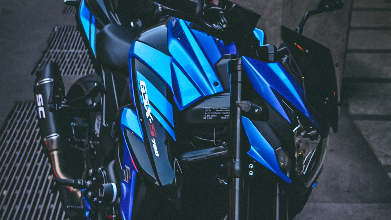 Blaues Und Schwarzes Motorrad Auf Grauem Betonpflaster Geparkt. Wallpaper in 1366x768 Resolution