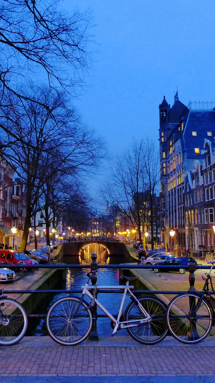 Bicycles Parked on Sidewalk Near Building During Night Time. Wallpaper in 750x1334 Resolution