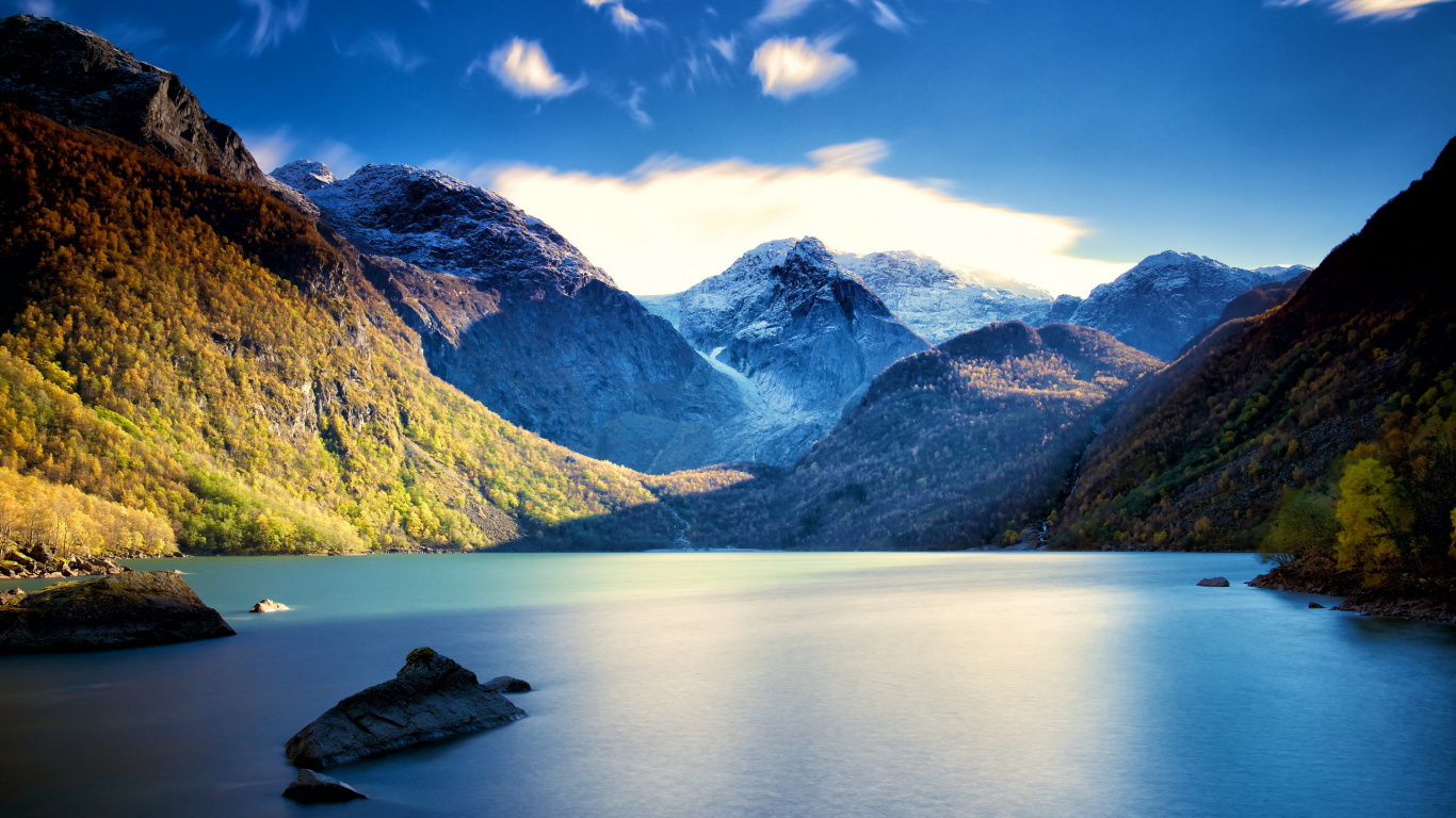 Grüne Und Weiße Berge Neben Gewässer Unter Blauem Himmel Tagsüber. Wallpaper in 1366x768 Resolution