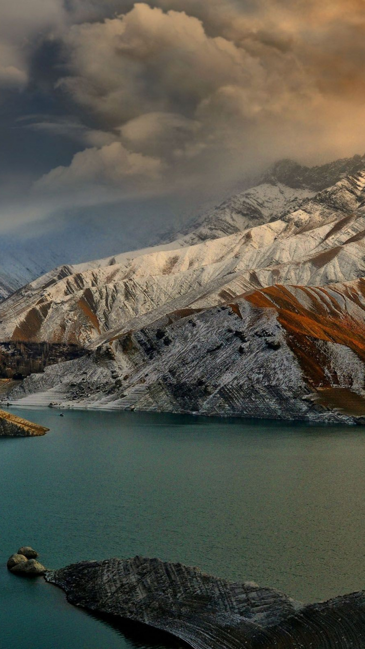 Body of Water Near Mountain Under Cloudy Sky During Daytime. Wallpaper in 750x1334 Resolution