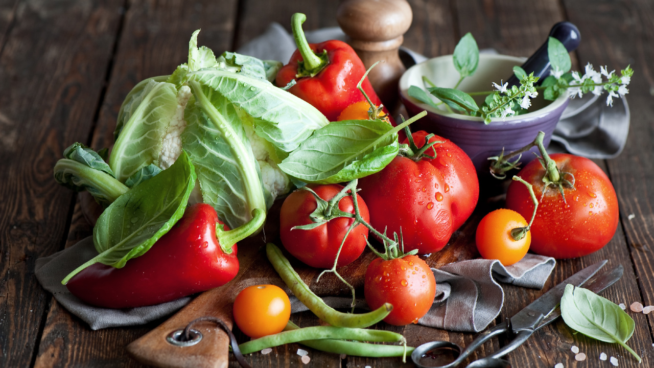 Red Tomato and Green Leaves on Brown Wooden Chopping Board. Wallpaper in 1280x720 Resolution