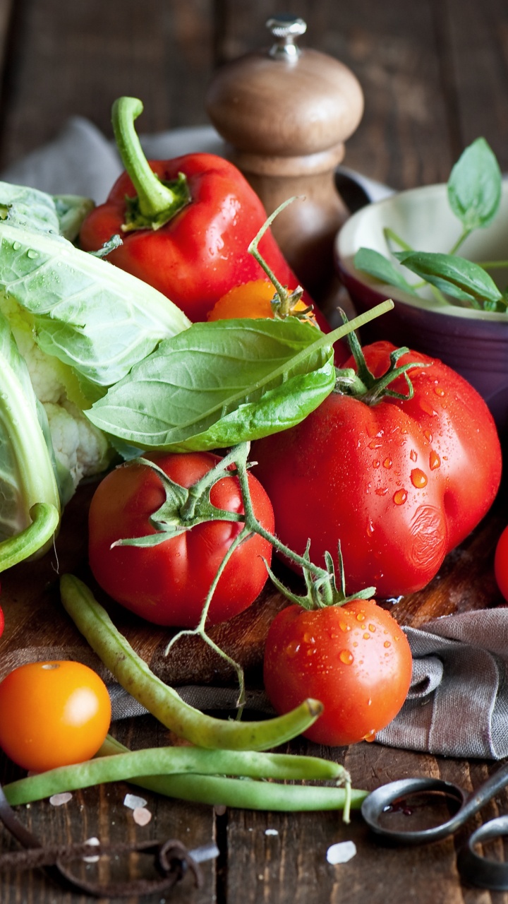 Red Tomato and Green Leaves on Brown Wooden Chopping Board. Wallpaper in 720x1280 Resolution