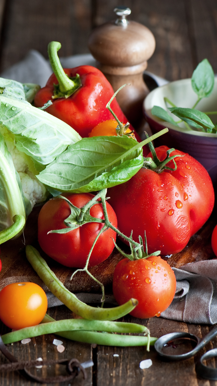 Red Tomato and Green Leaves on Brown Wooden Chopping Board. Wallpaper in 750x1334 Resolution