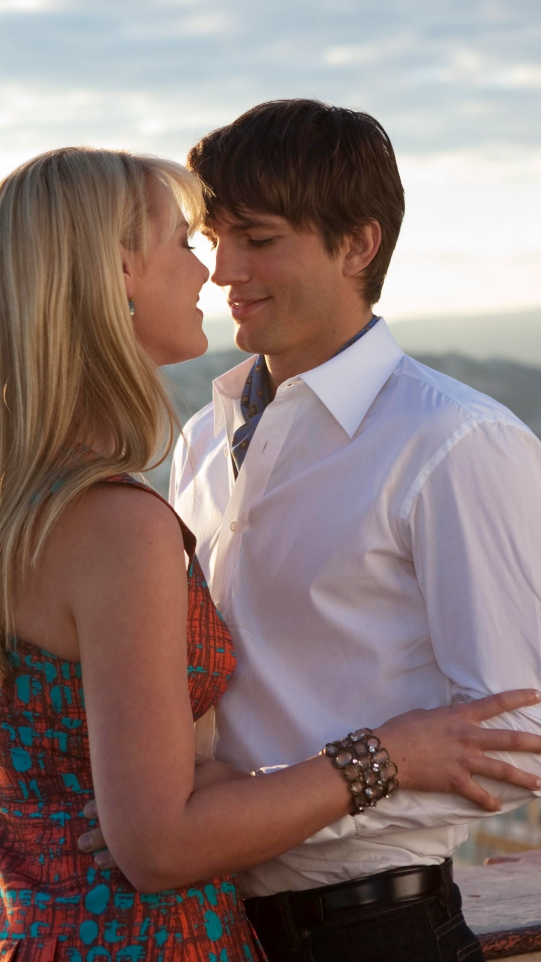 Man in White Suit Kissing Woman in Red and Blue Sleeveless Dress. Wallpaper in 1080x1920 Resolution