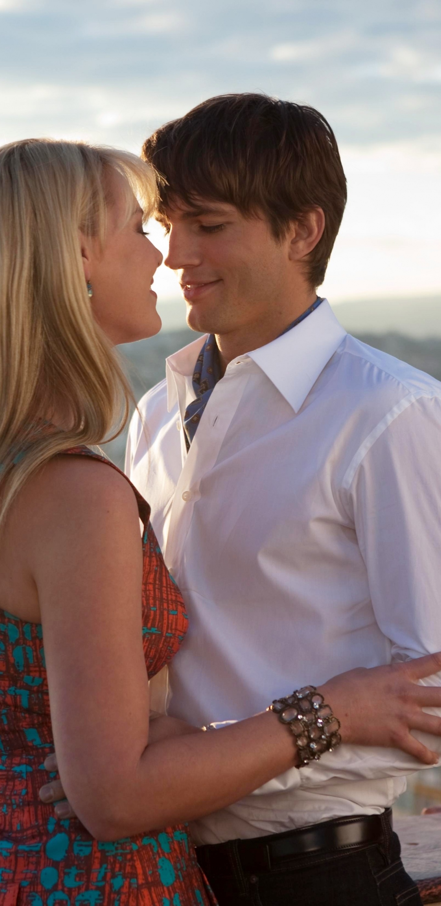 Man in White Suit Kissing Woman in Red and Blue Sleeveless Dress. Wallpaper in 1440x2960 Resolution