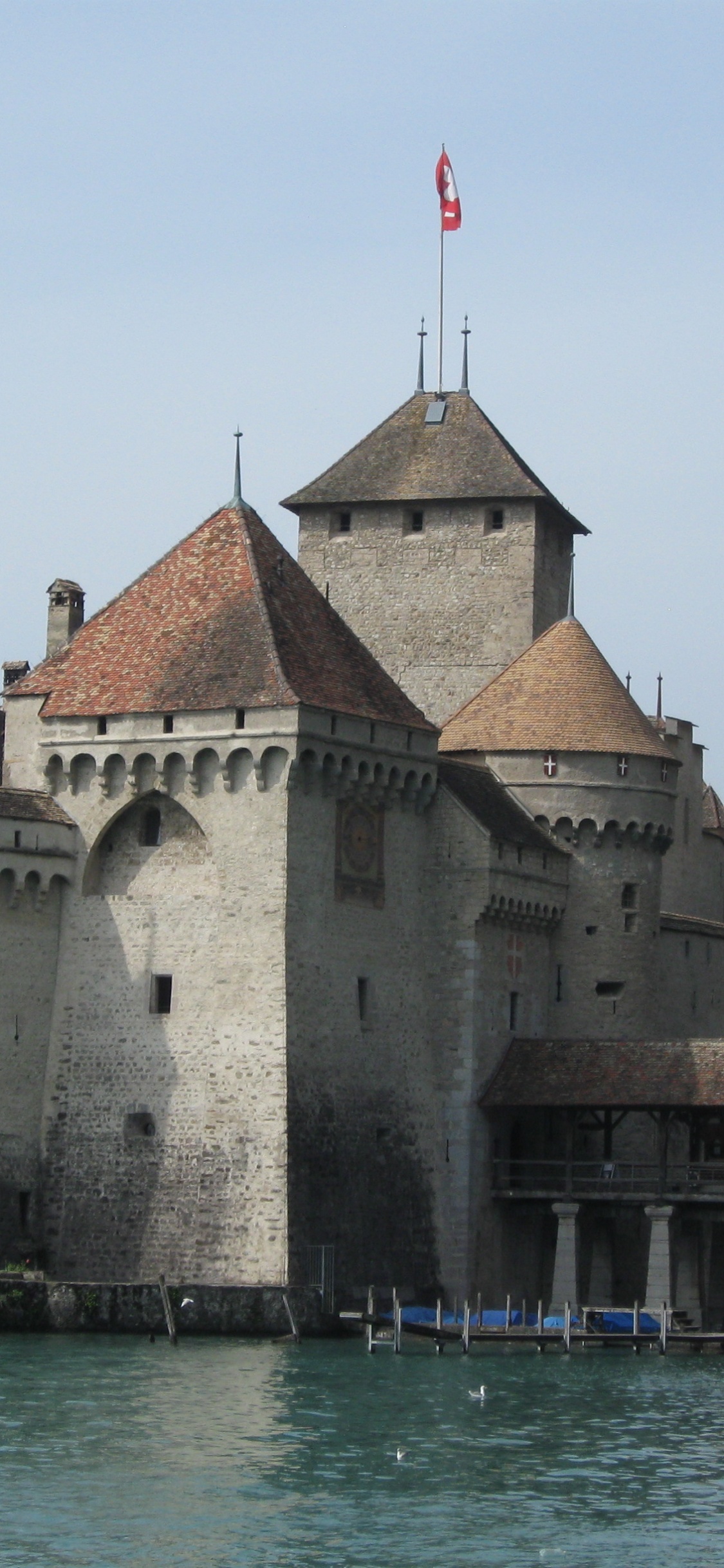 Bâtiment en Béton Brun et Gris Près D'un Plan D'eau Pendant la Journée. Wallpaper in 1125x2436 Resolution