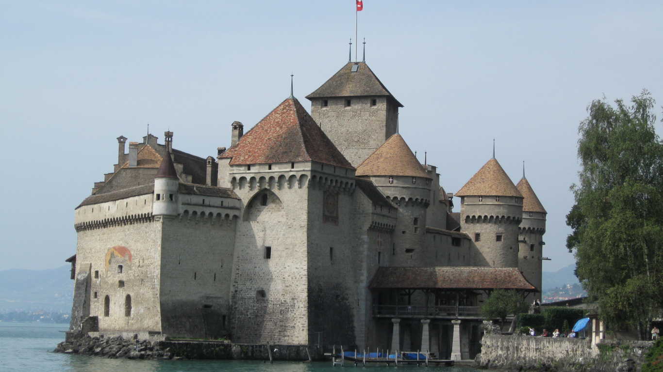 Bâtiment en Béton Brun et Gris Près D'un Plan D'eau Pendant la Journée. Wallpaper in 1366x768 Resolution