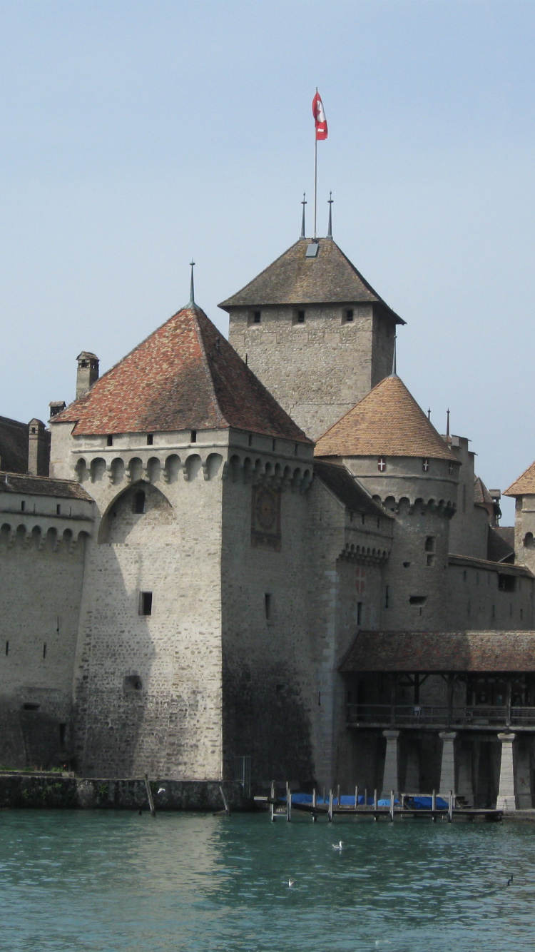 Bâtiment en Béton Brun et Gris Près D'un Plan D'eau Pendant la Journée. Wallpaper in 750x1334 Resolution
