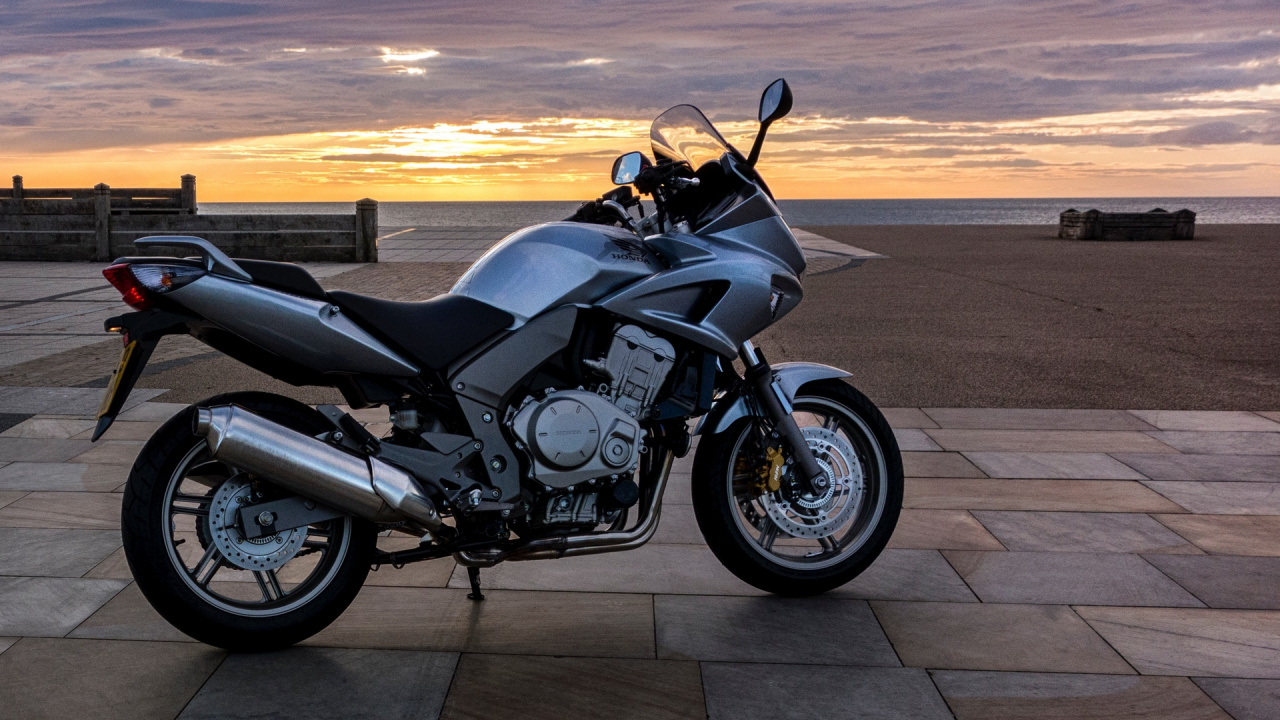 Schwarz-silbernes Cruiser-Motorrad Auf Grauer Betonstraße Bei Sonnenuntergang. Wallpaper in 1280x720 Resolution