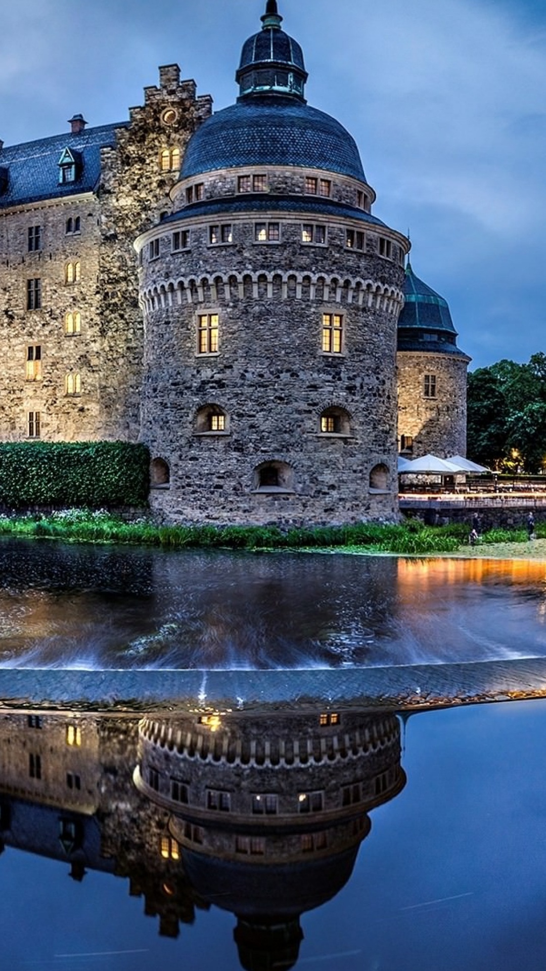 Brown Concrete Building Near Body of Water During Night Time. Wallpaper in 1080x1920 Resolution