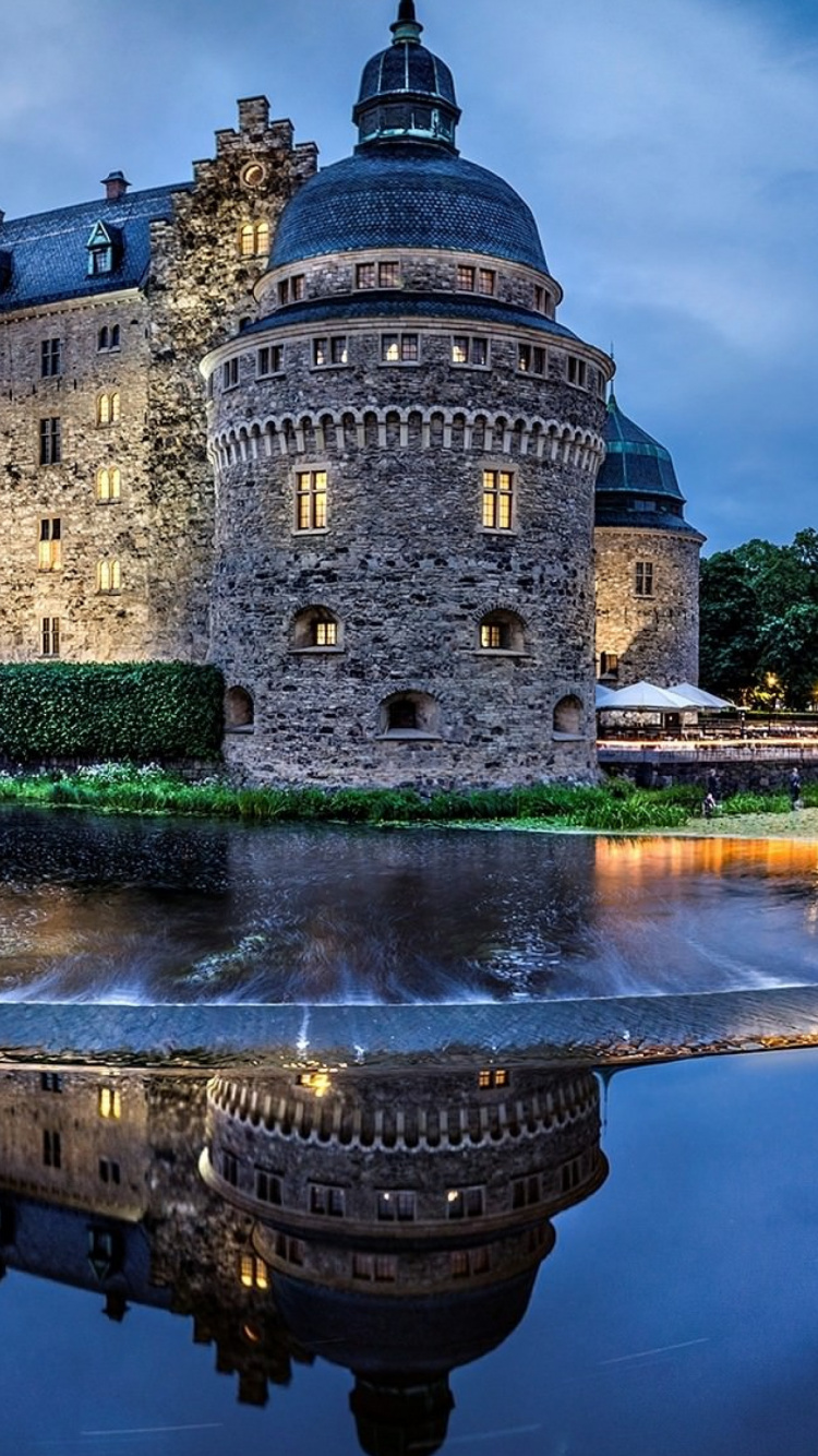 Bâtiment en Béton Brun Près D'un Plan D'eau Pendant la Nuit. Wallpaper in 750x1334 Resolution