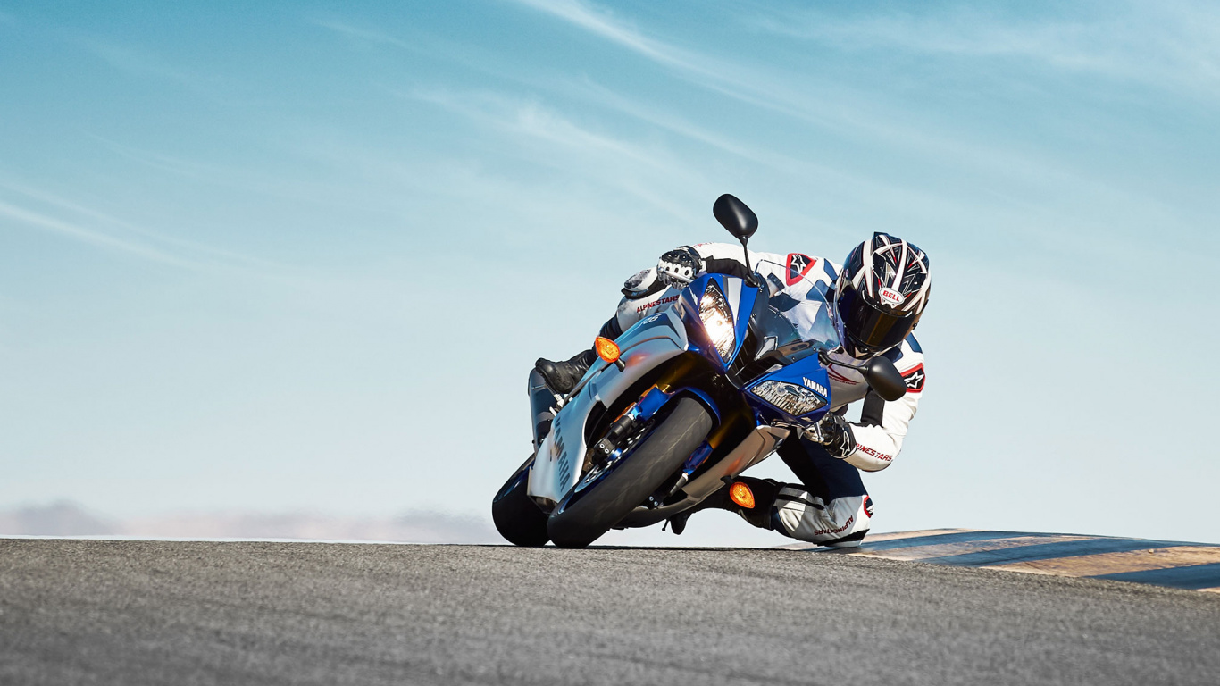 Man in Blue and White Sports Bike Suit Riding on Blue Sports Bike on Gray Asphalt. Wallpaper in 1366x768 Resolution