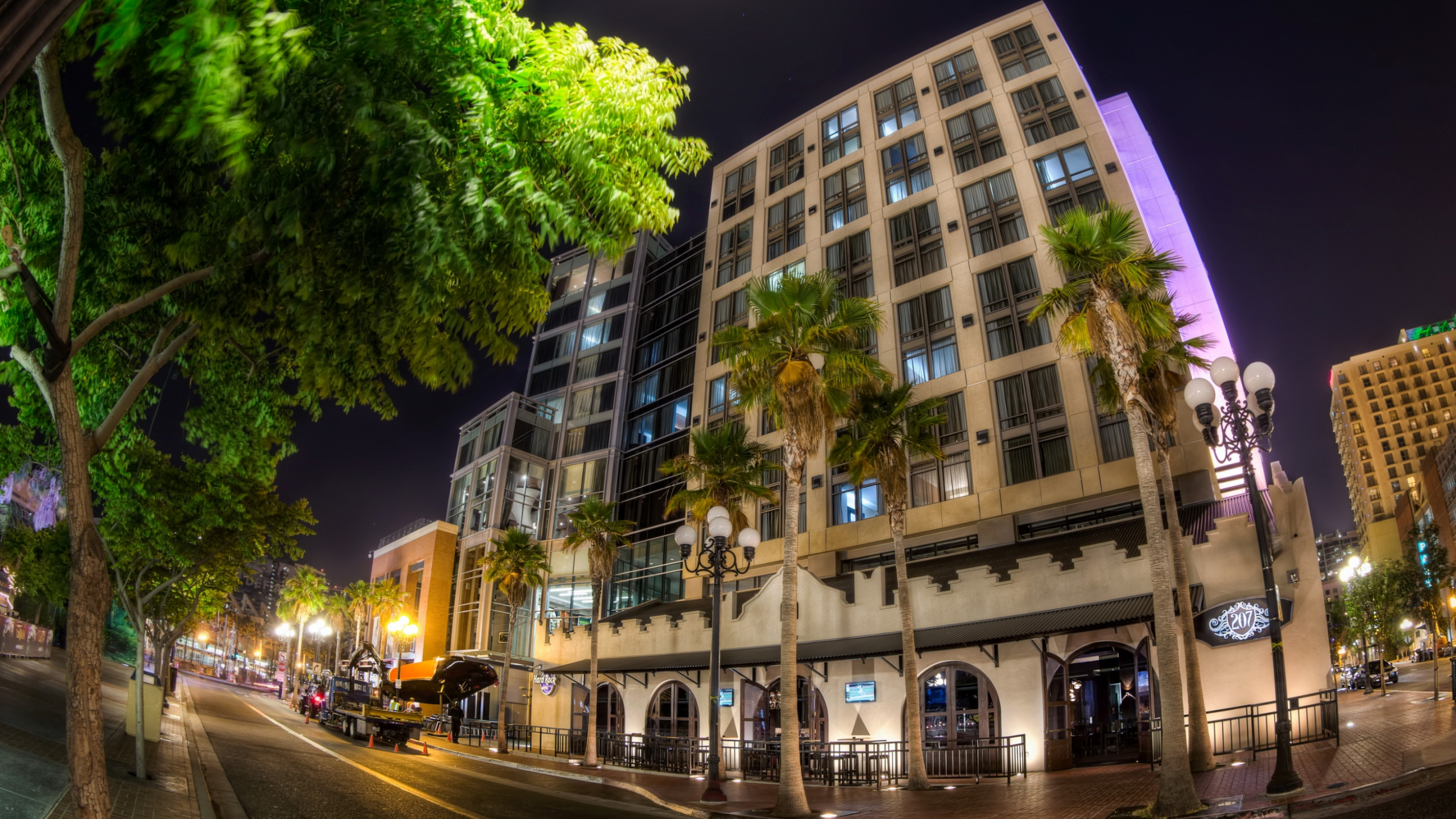 Coches Aparcados Junto al Edificio Durante la Noche. Wallpaper in 2560x1440 Resolution
