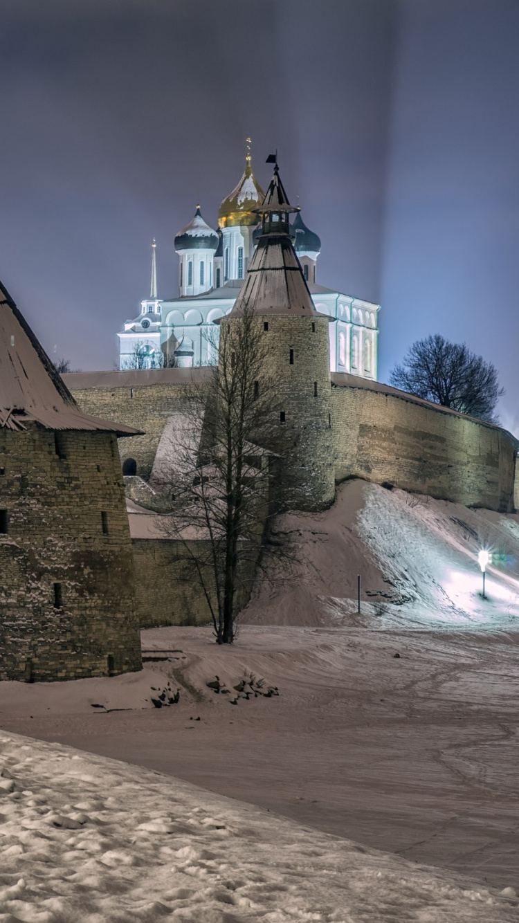 Braunes Betongebäude in Der Nähe Von Gewässern Während Der Nacht. Wallpaper in 750x1334 Resolution