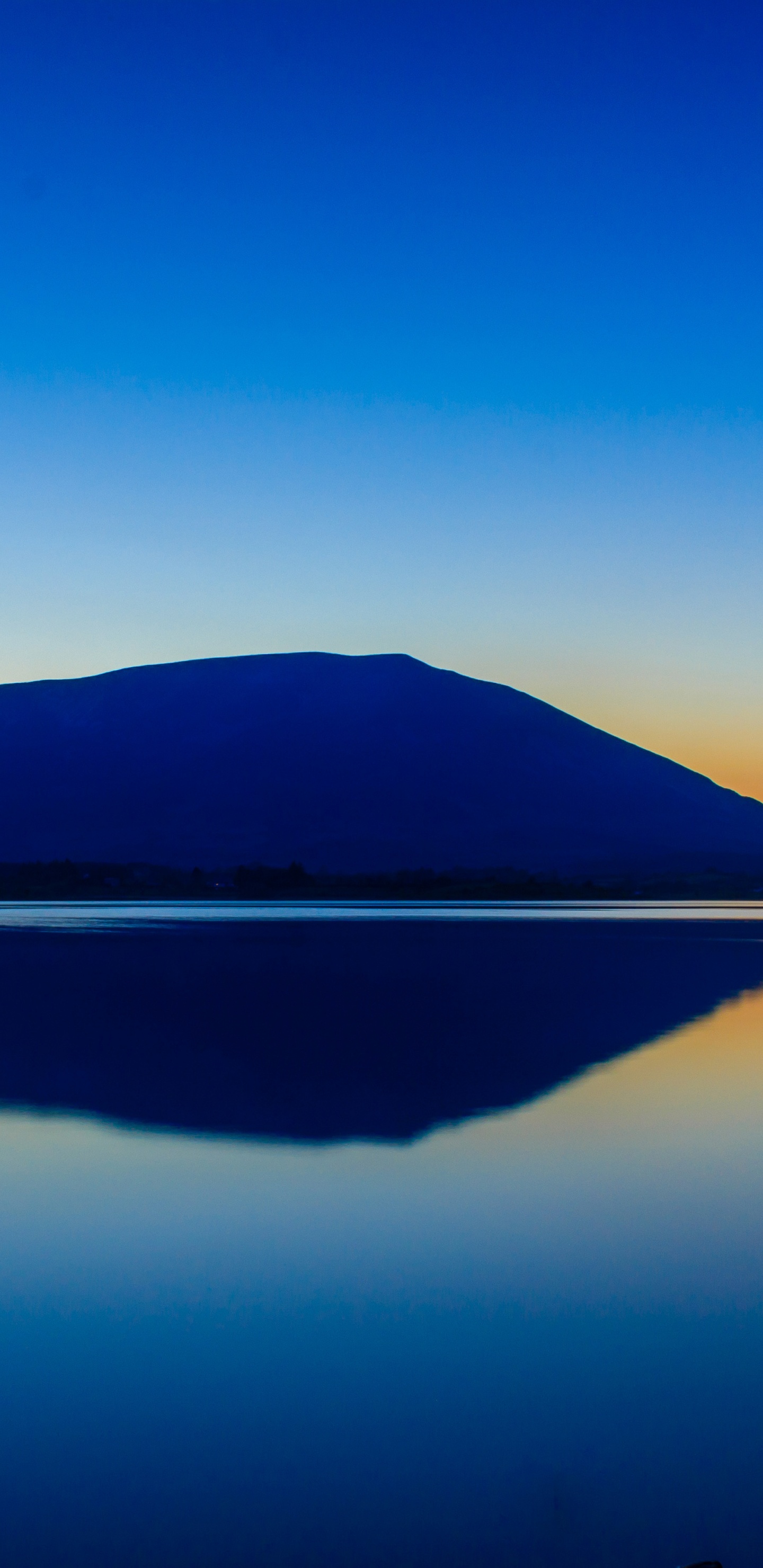 Cuerpo de Agua Cerca de la Montaña Bajo un Cielo Azul Durante el Día. Wallpaper in 1440x2960 Resolution