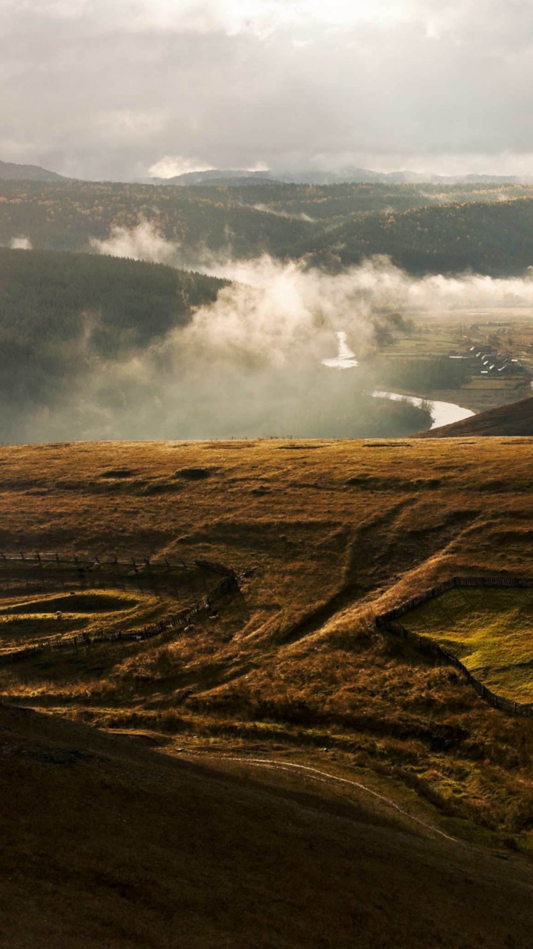 Brauner Berg Unter Weißen Wolken Tagsüber. Wallpaper in 750x1334 Resolution
