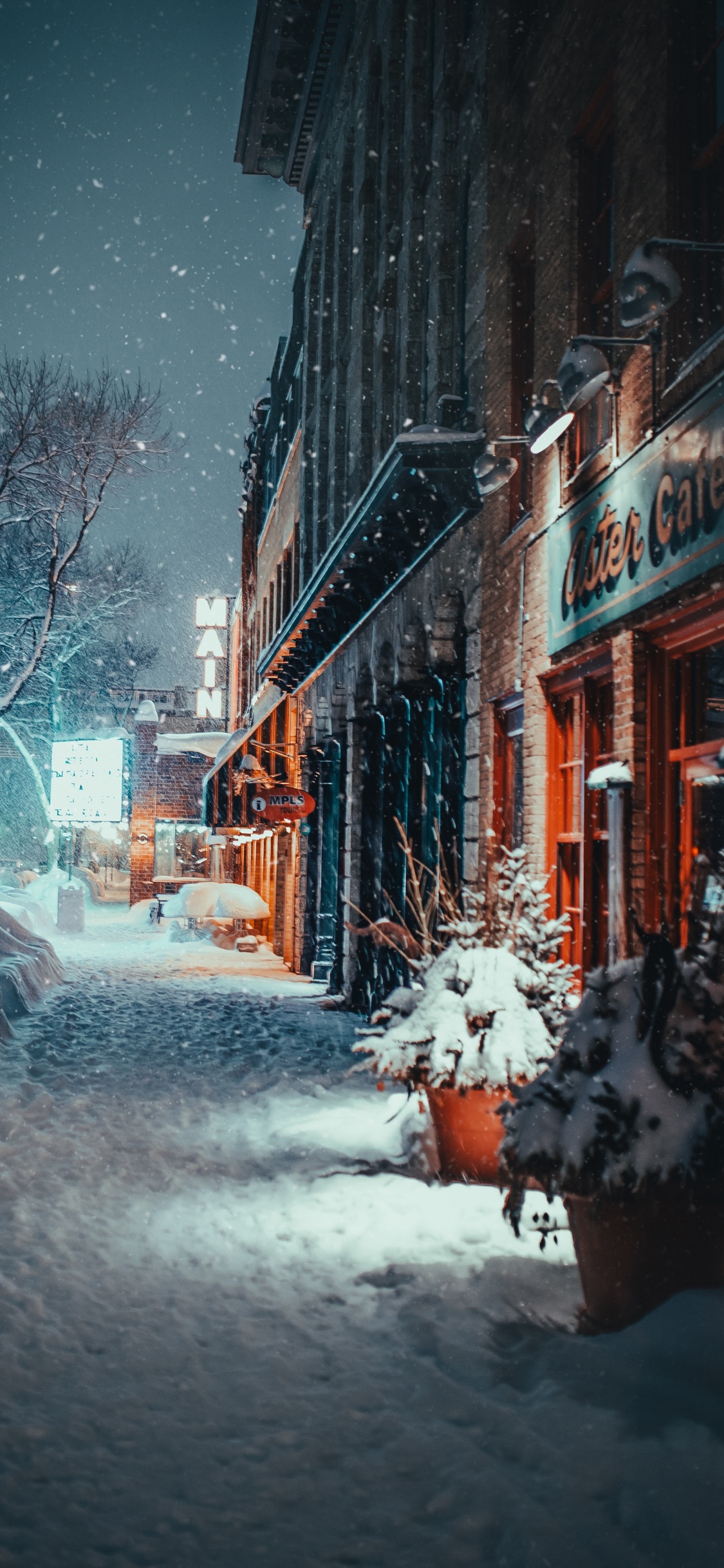 Snow Covered Road Between Buildings During Daytime. Wallpaper in 1125x2436 Resolution