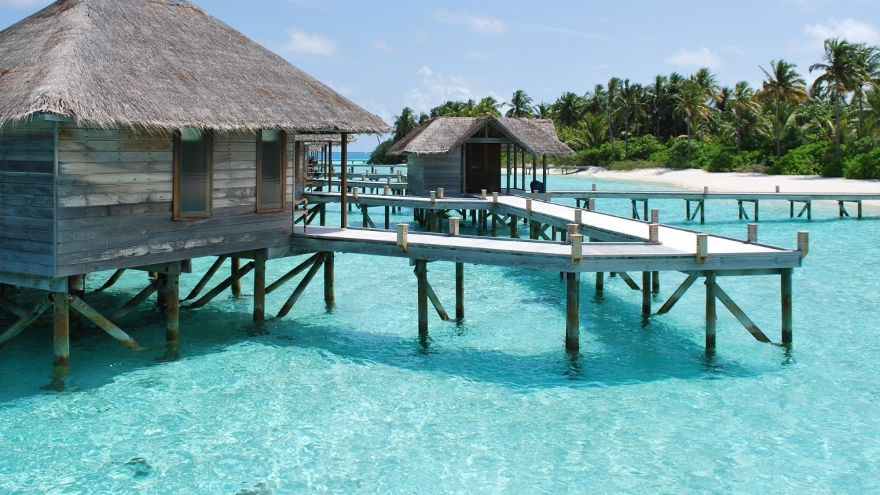 Brown Wooden House on Blue Sea Under Blue Sky During Daytime. Wallpaper in 1280x720 Resolution
